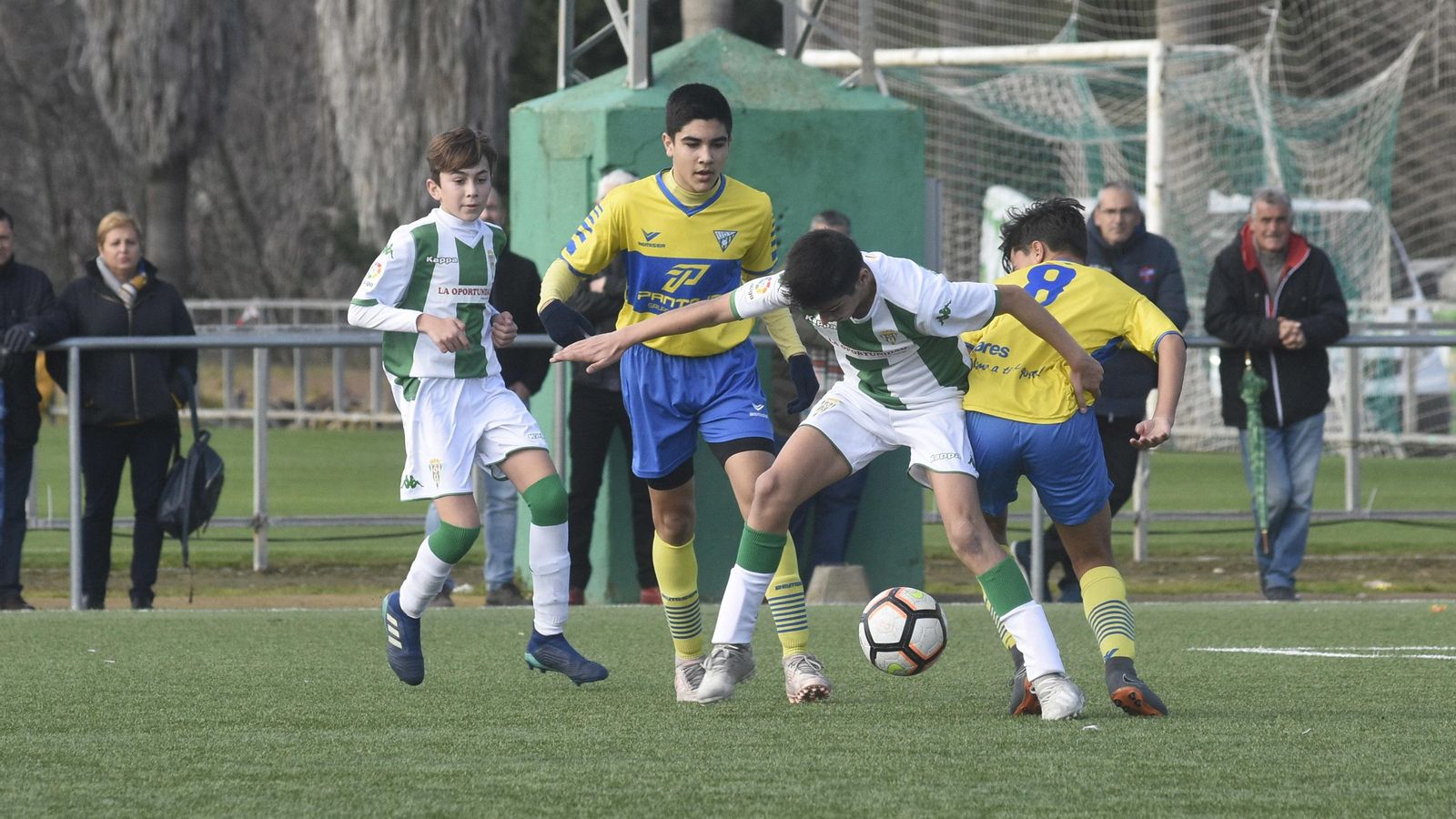 Un jugador blanquiverde protege el balón ante dos rivales del Tomares.