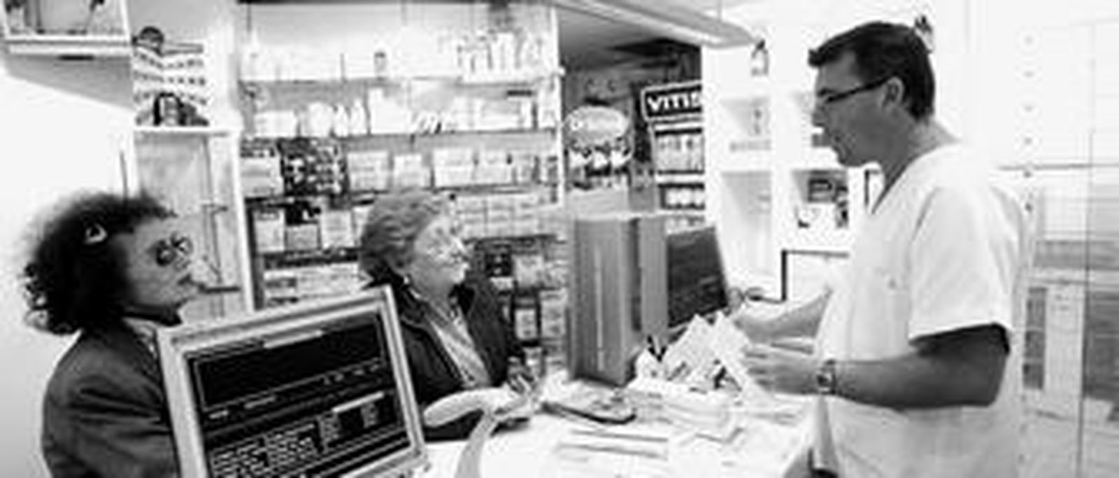 Augusto Santana atiende a un par de clientas en la Farmacia Caffarena, en la Alameda Principal.