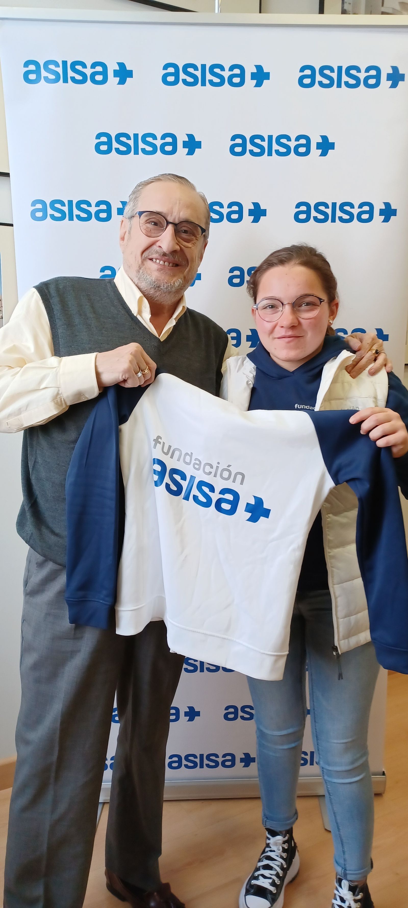 El delegado de ASISA en Cádiz, Dr. Francisco Javier Rodriguez Moragues, entrega el material deportivo a Aitana Estrada.