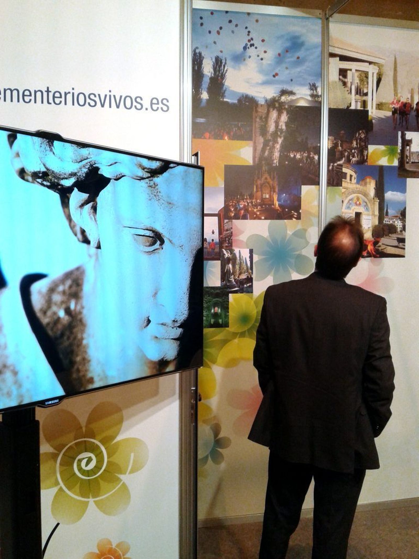 Un visitante contempla el stand de 'Cementerios Vivos' en Fitur.