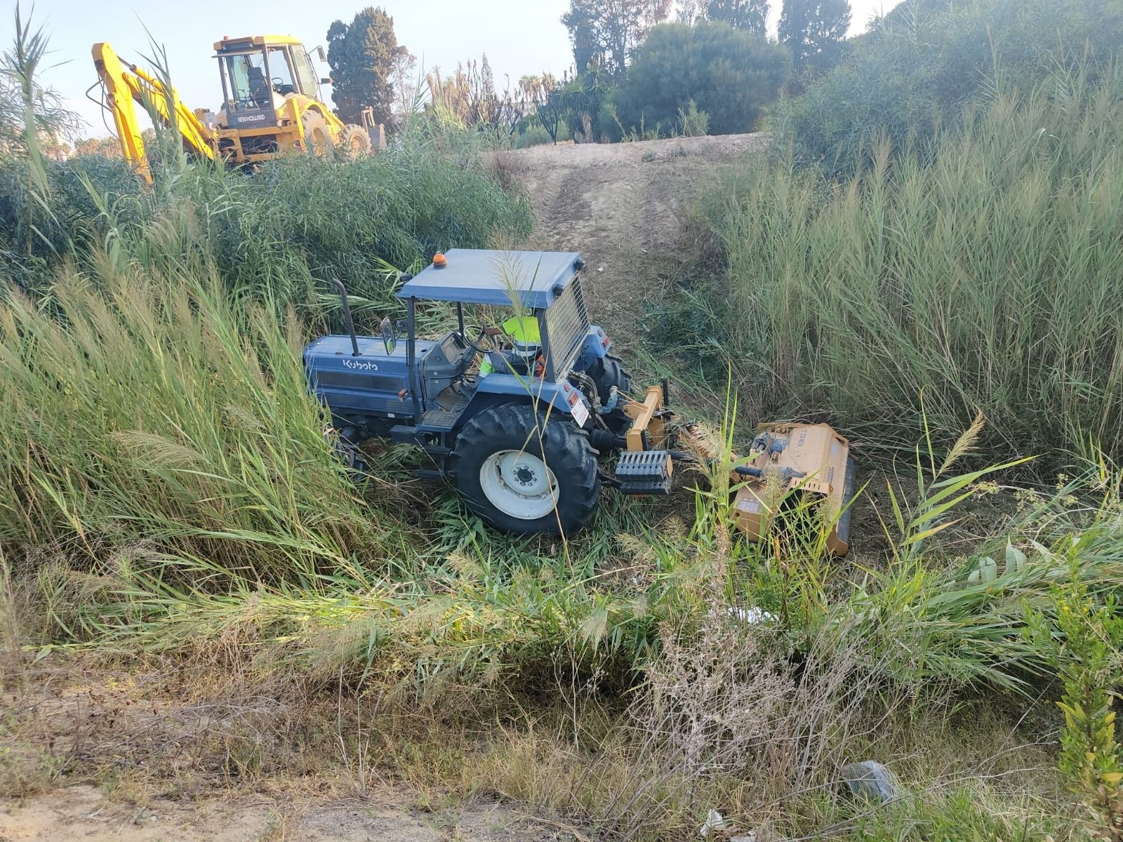 Un operario realizando labores de limpieza en un arroyo.