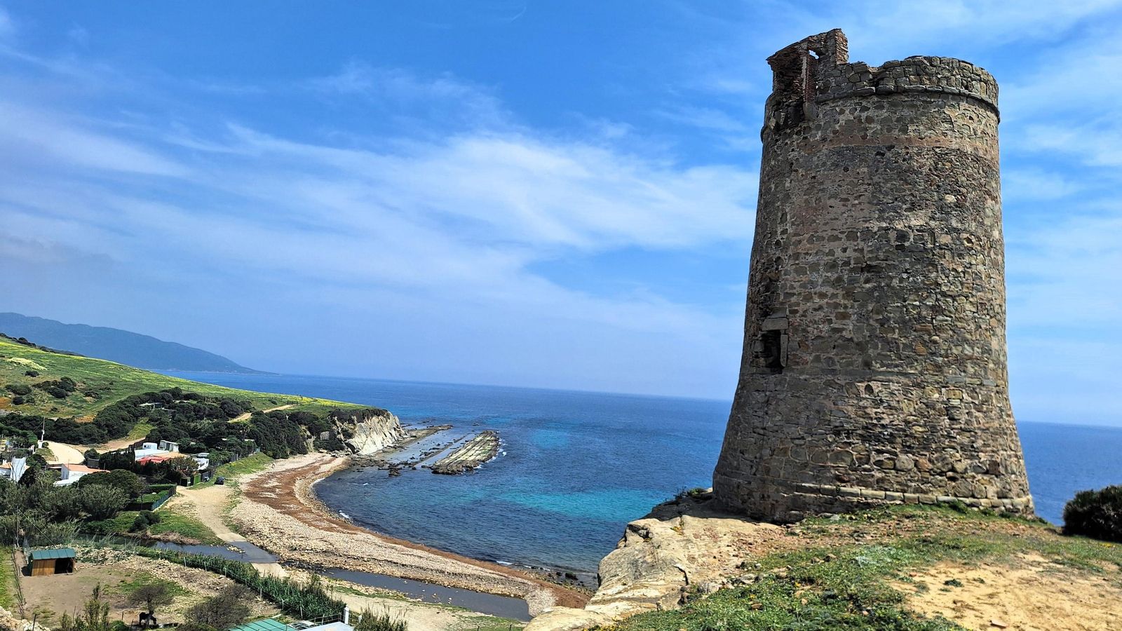 Torre atalaya de Guadalmesí, mandada construir en 1588 por Felipe II. A sus pies, el arroyo y la cala de Guadalmesí.