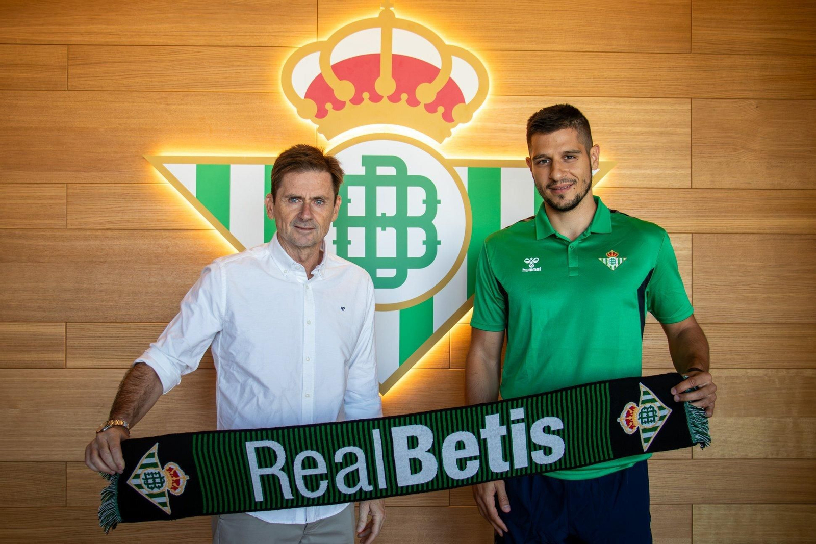 Rosko Rogic posa con una bufanda del Betis junto al director deportivo, Armando Guerrero.