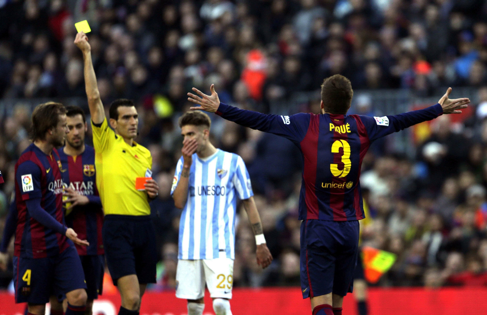 Martínez Munuera enseña una tarjeta amarilla a Piqué en el Camp Nou.
