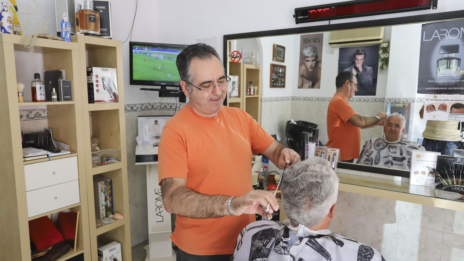 Angel Díaz le corta el pelo a su vecino Claudio Atencia