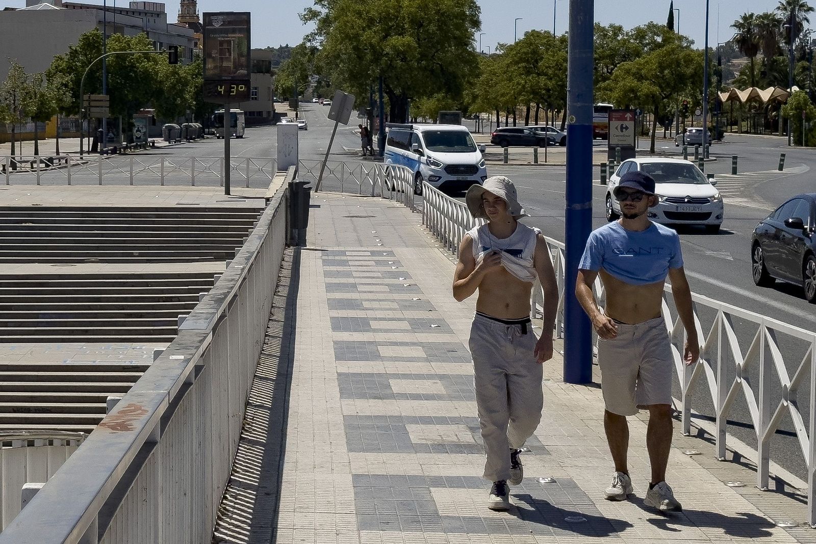 Dos jóvenes soportan los 43 grados que marca el termómetro en Sevilla.