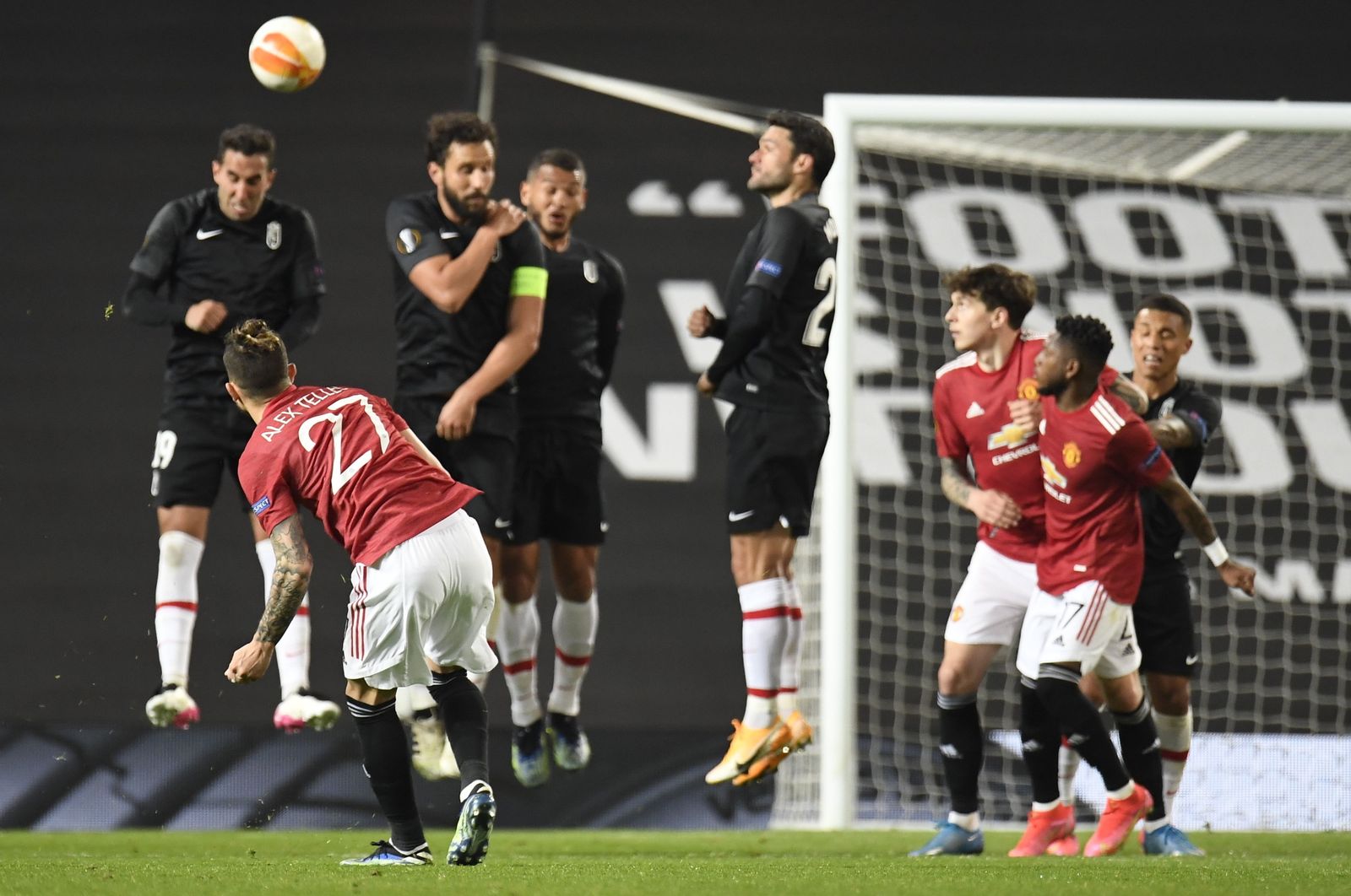 Los jugadores del Granada CF defienden una falta botada por Telles en Old Trafford.