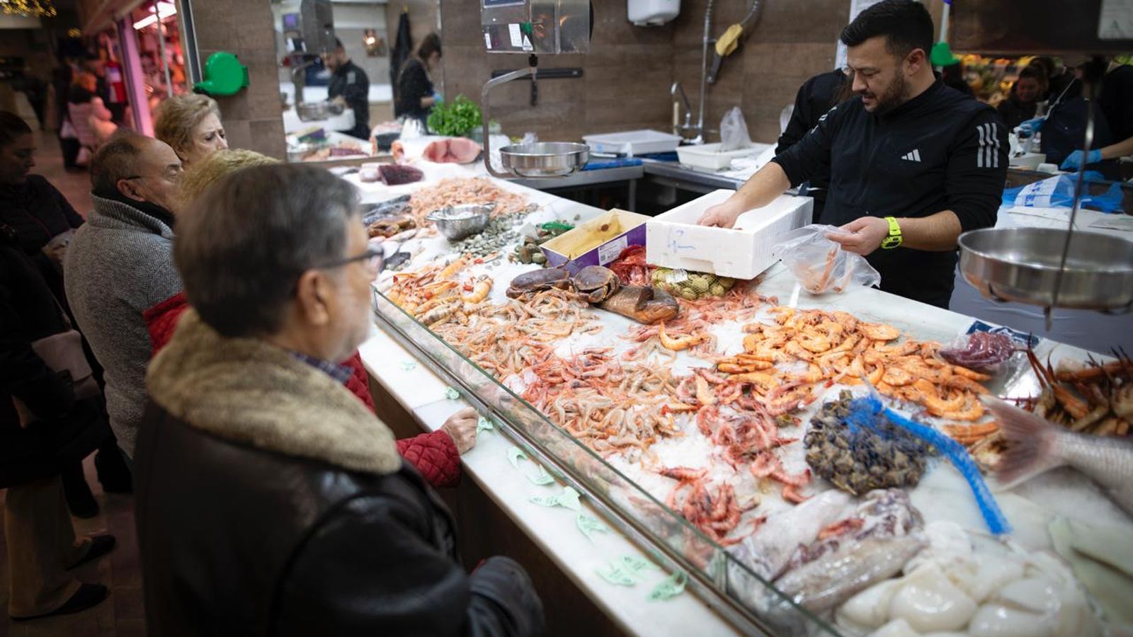 Varias personas esperan su turno en una de las pescaderías