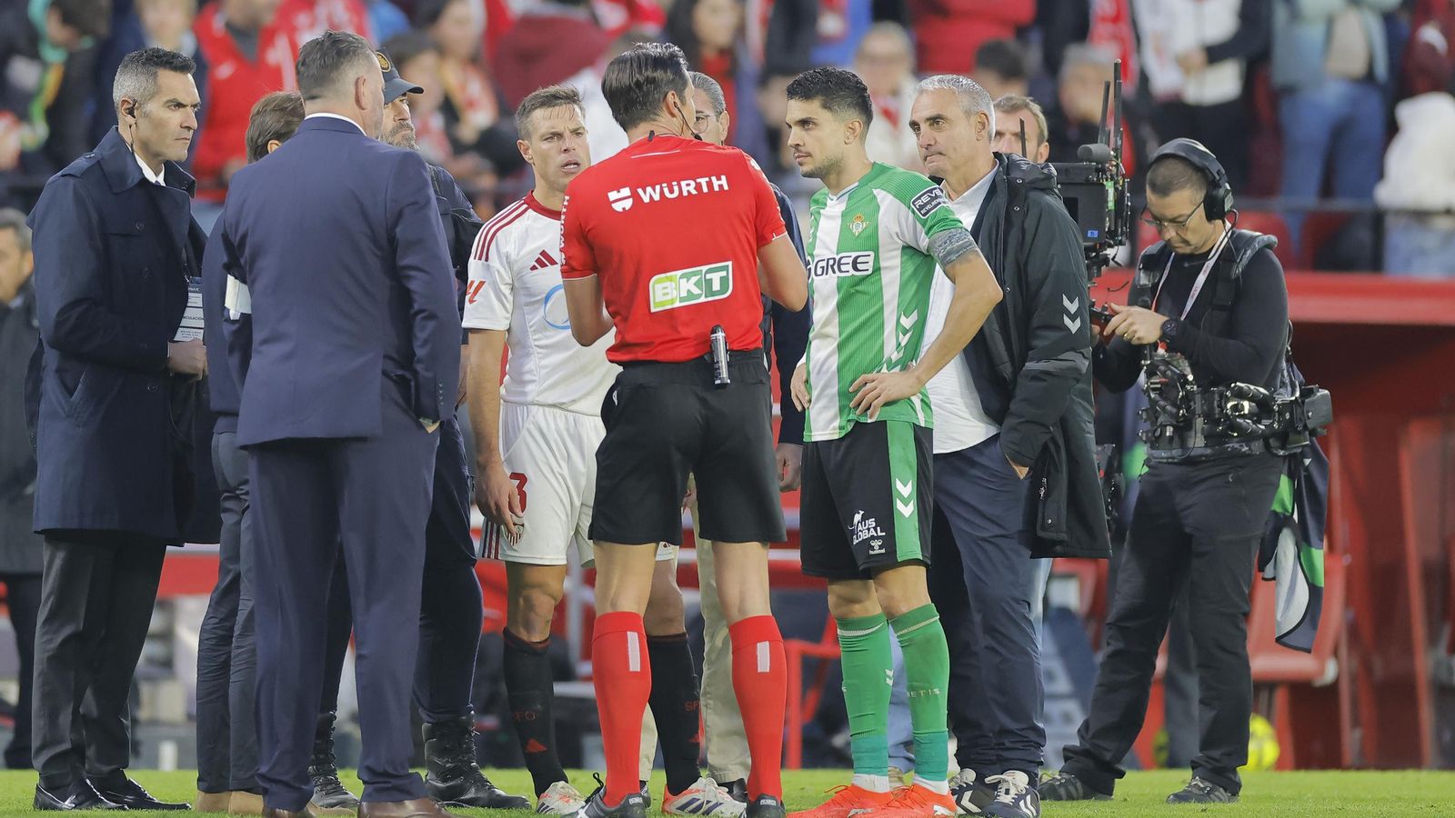 Munuera Montero explica a los delegados y capitanes del Sevilla y el Betis la suspensión del partido.