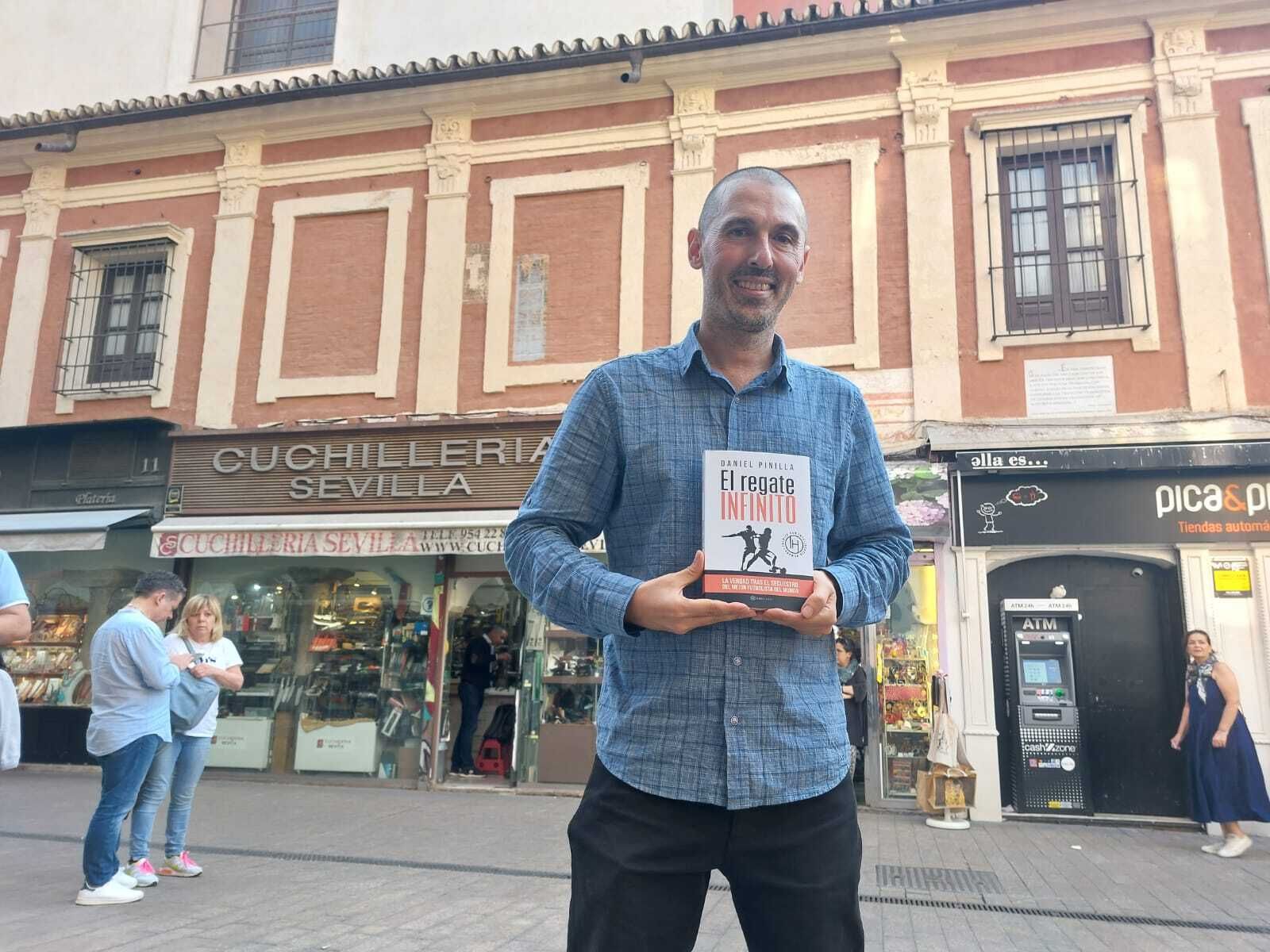 Dani Pinilla posa con 'El regate infinito' ante uno de los escasos negocios tradicionales que quedan en la Plaza del Pan.