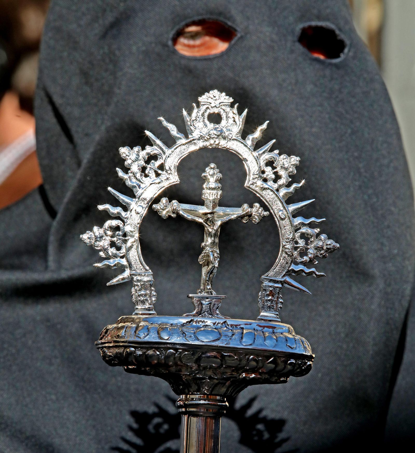 Un hermano de la Vera Cruz de la presidencia del paso de misterio sostiene una vara en los primeros compases de su estación de penitencia.