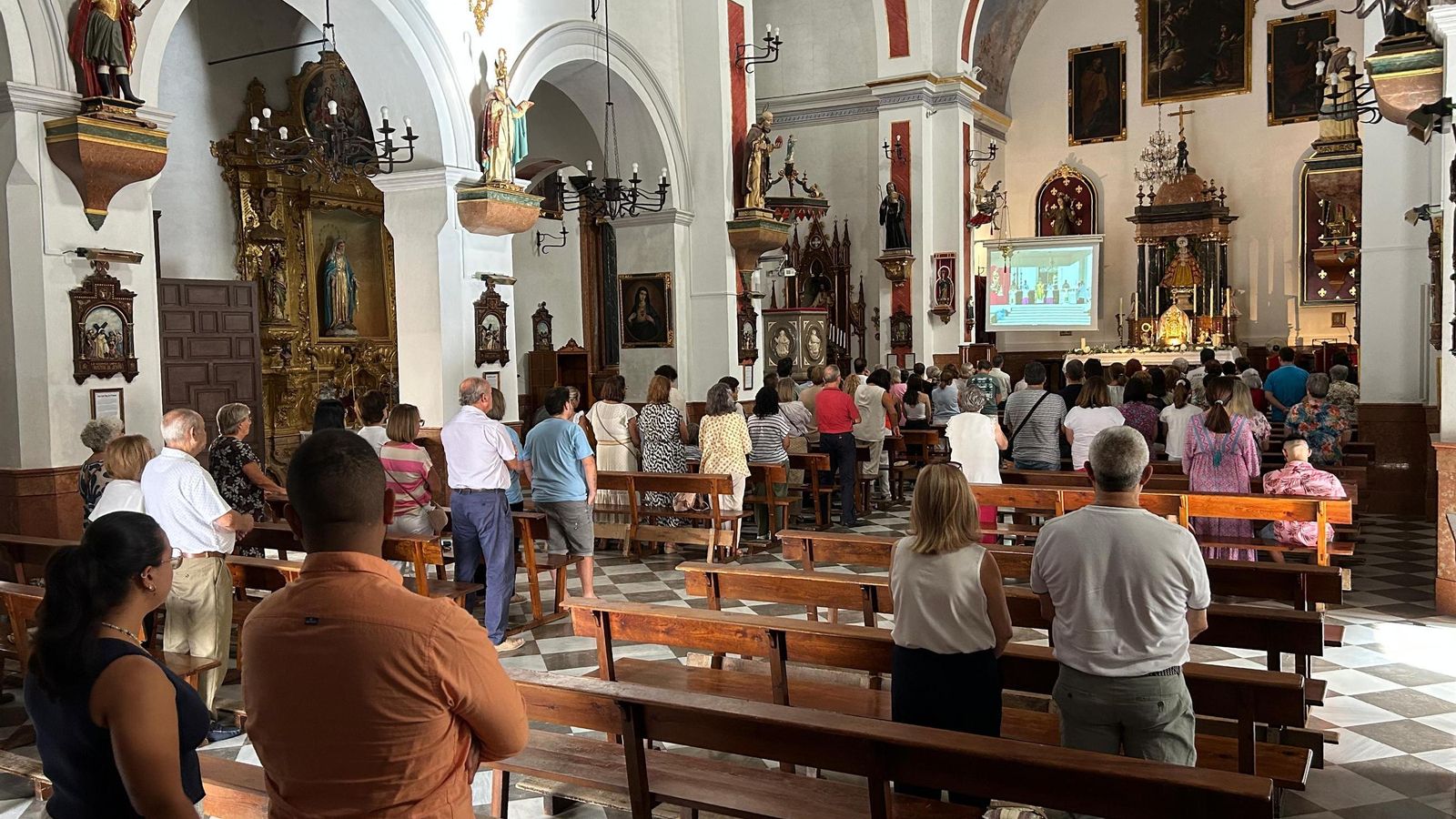 Fieles en la iglesia para seguir la canonización.