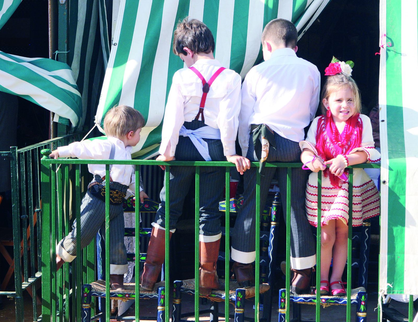 1. Los niños aprovechan la Feria para jugar en las casetas y con el albero.  2. Las chapas de La Tita Ana tienen mensajes con humor para localizar a los pequeños.            3. Policía local, Bomberos y Protección Civil repartirán pulseras identificativas que facilitan la localización de los menores que se pierdan.