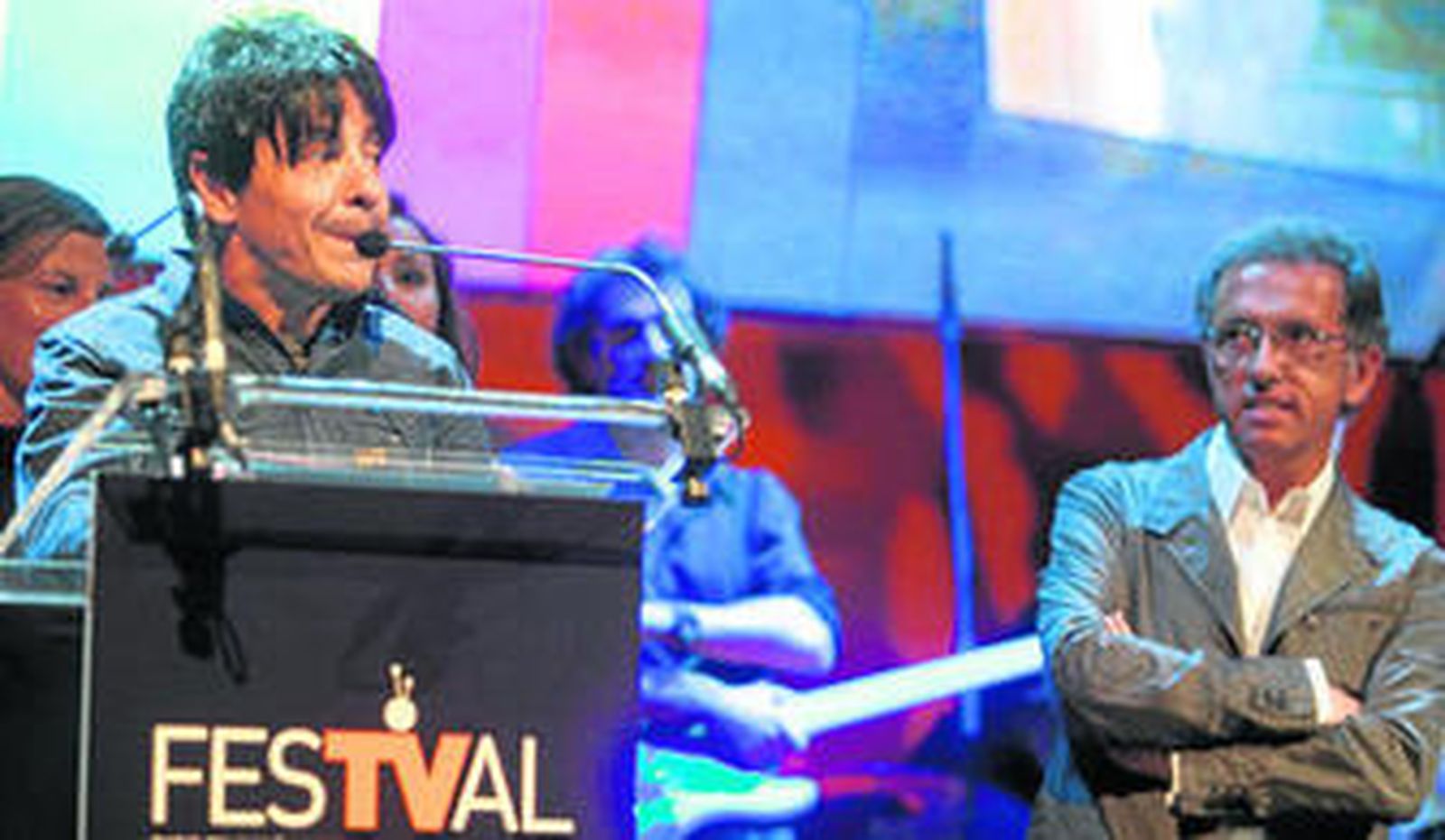 Ortega al recibir el premio del Festival de Vitoria por el programa de La 2 'La mitad invisible', de manos de Jordi Hurtado, que le escucha atentamente.