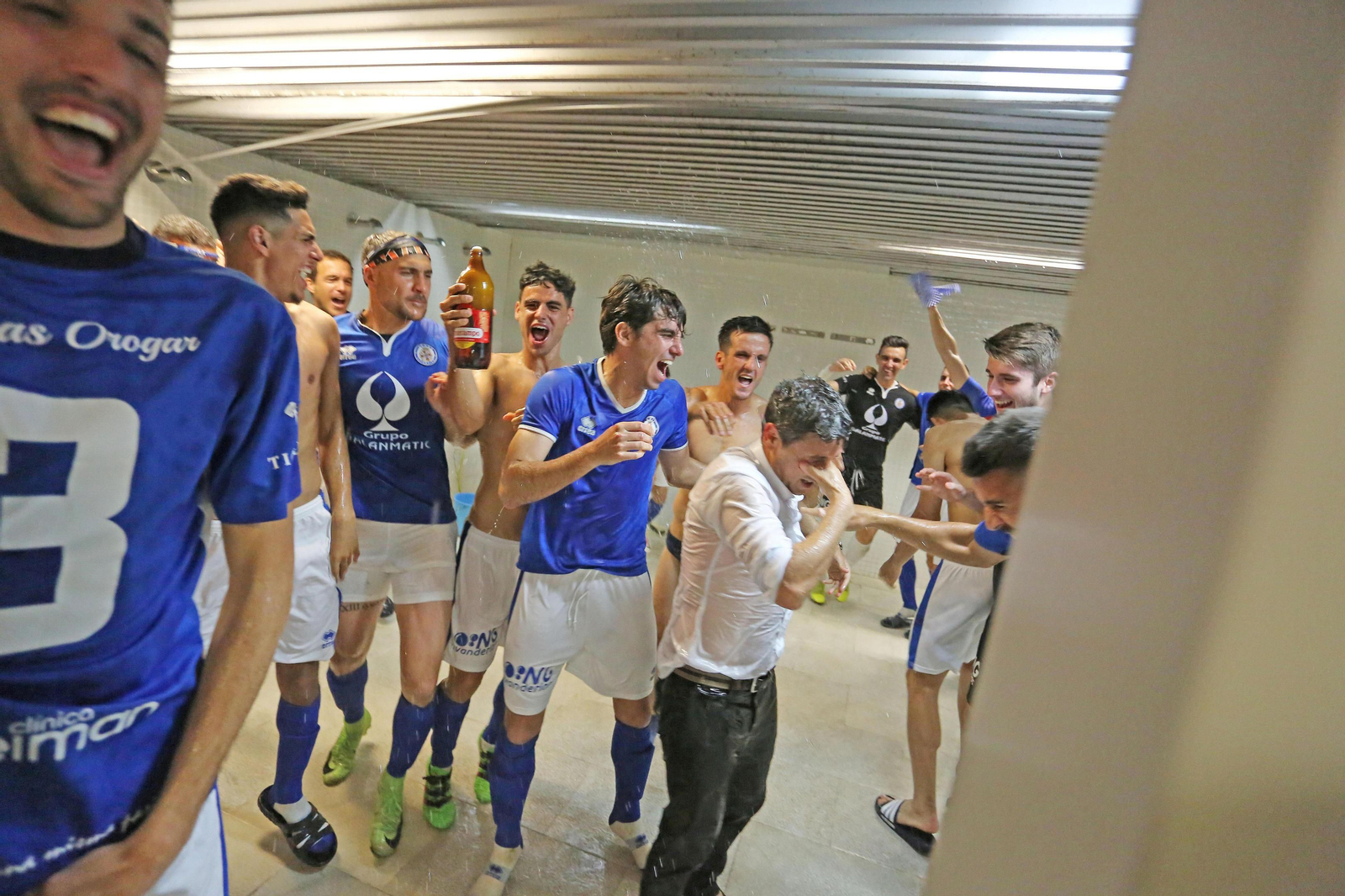 Pepe Masegosa, entrenador azulino, pese a que lo intentó en varias ocasiones, no se pudo librar de la ducha, en la que lo metieron sus jugadores.
