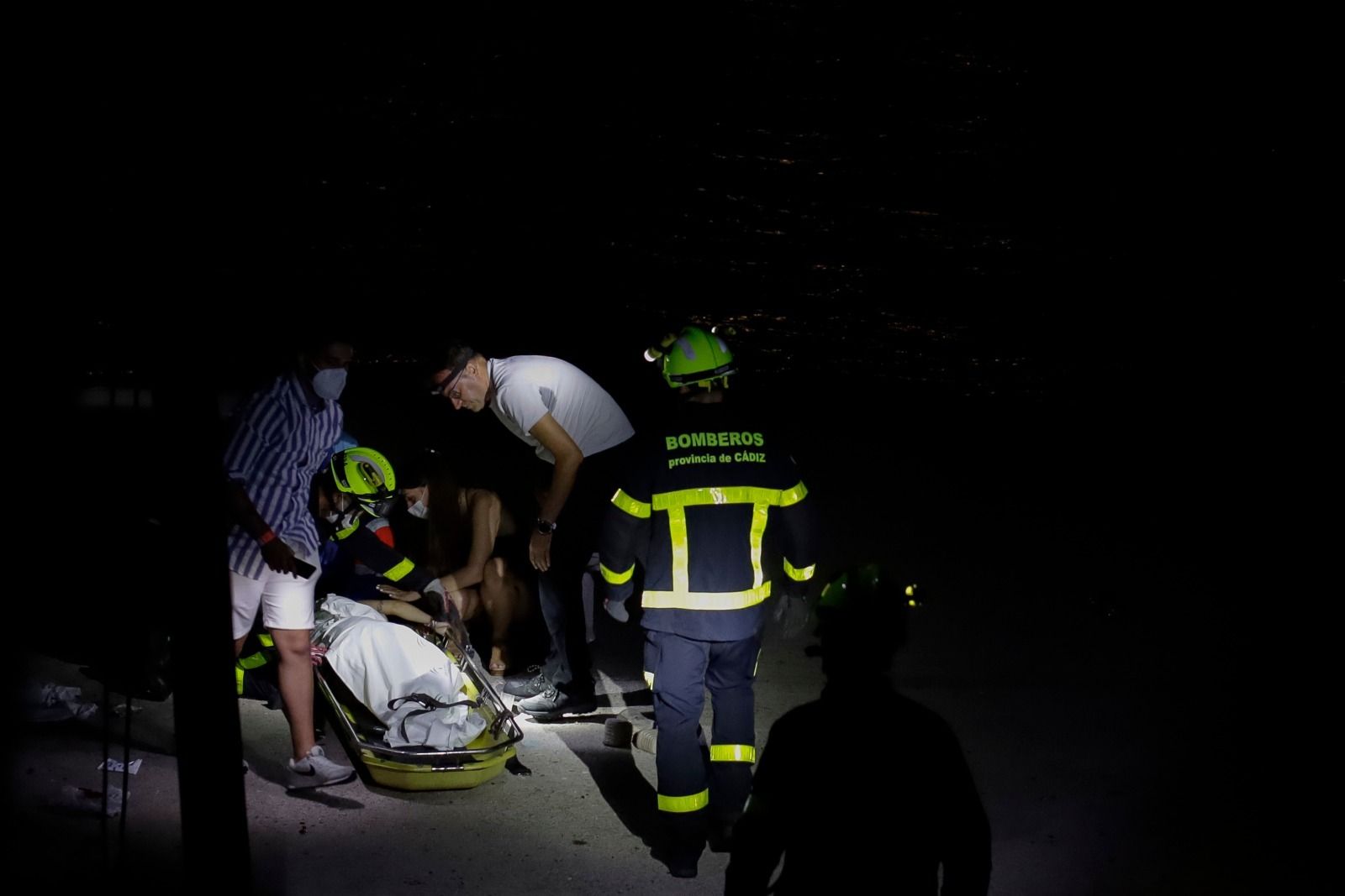 Los bomberos proceden a asegurar la camilla durante el rescate de la joven en la Punta de San Felipe.