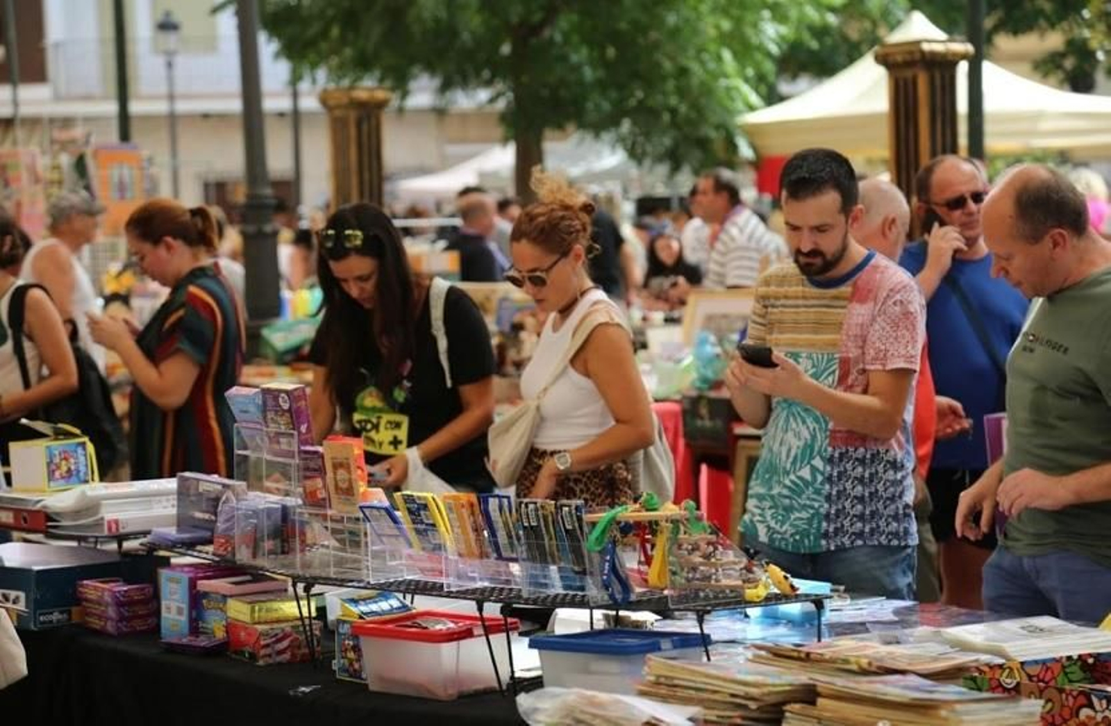 Varios visitantes revisan artículos expuestos en una anterior edición.