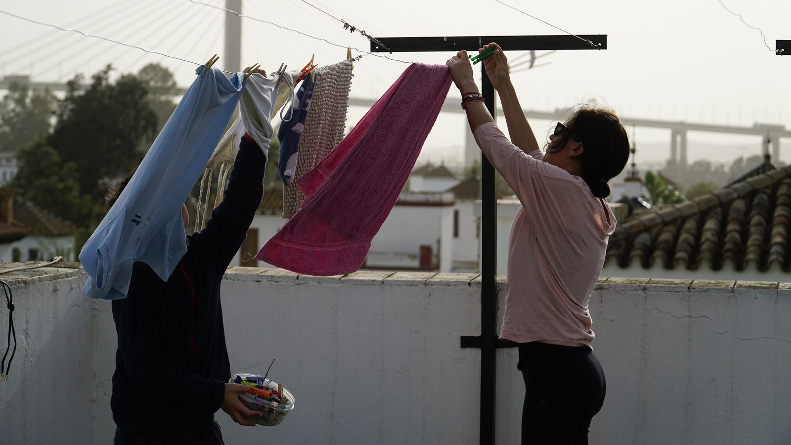 Una mujer y un niño tienden en una azotea.