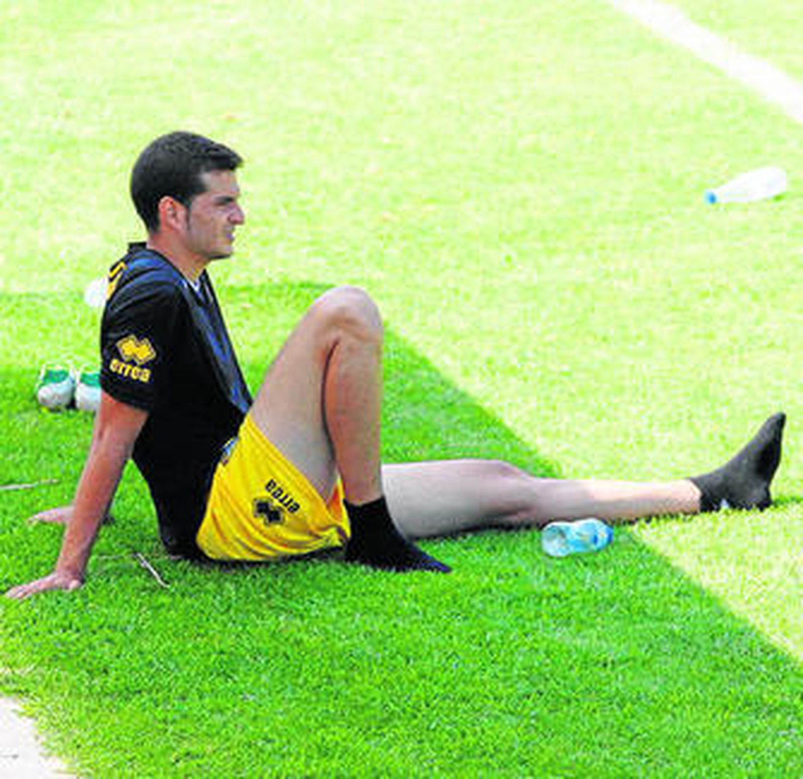 Kike López (i) y Perico sostienen la bufanda durante el posado sobre el campo principal de El Rosal.