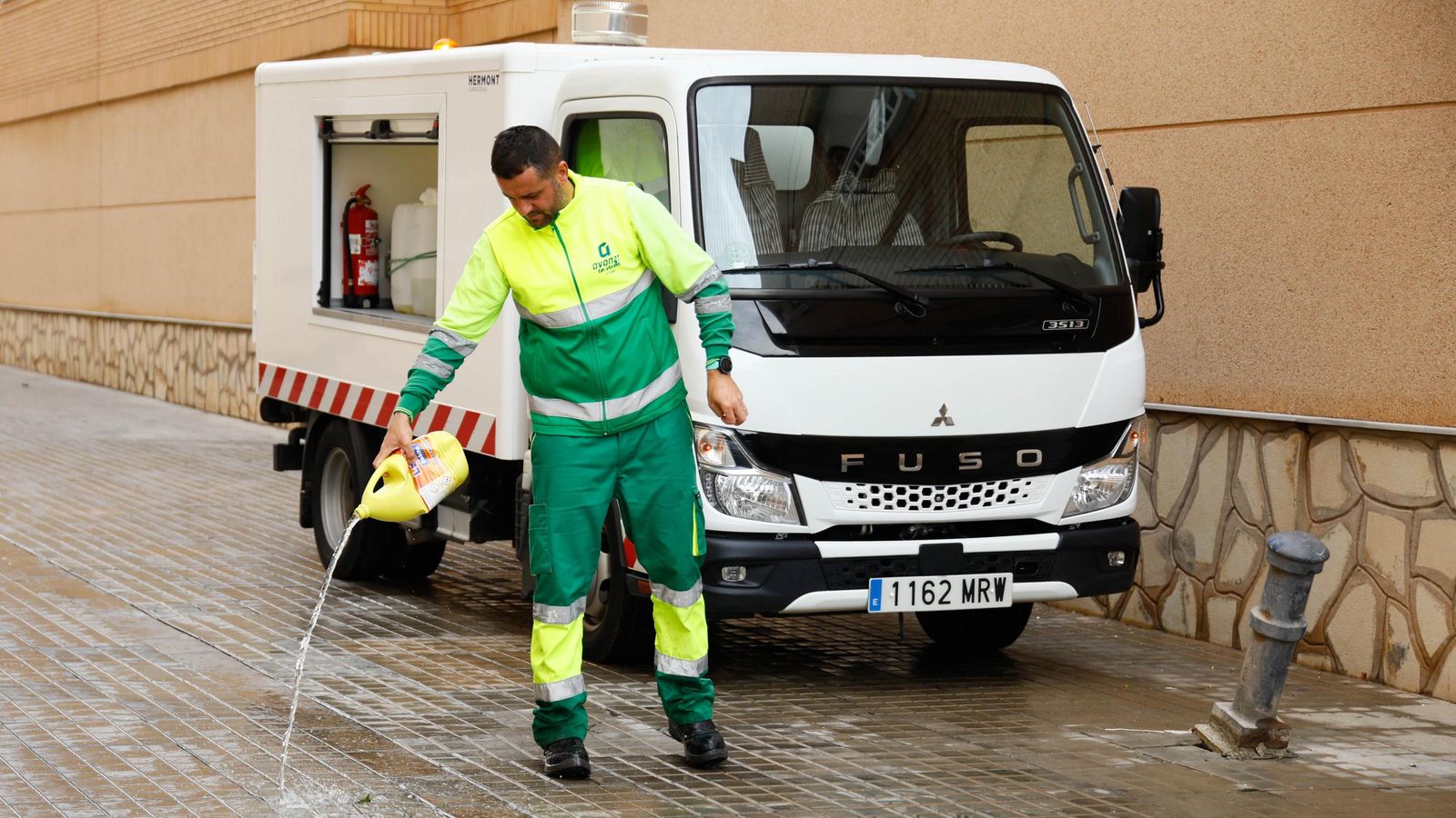 Un operario limpia la calle en la que se ha producido el crimen.