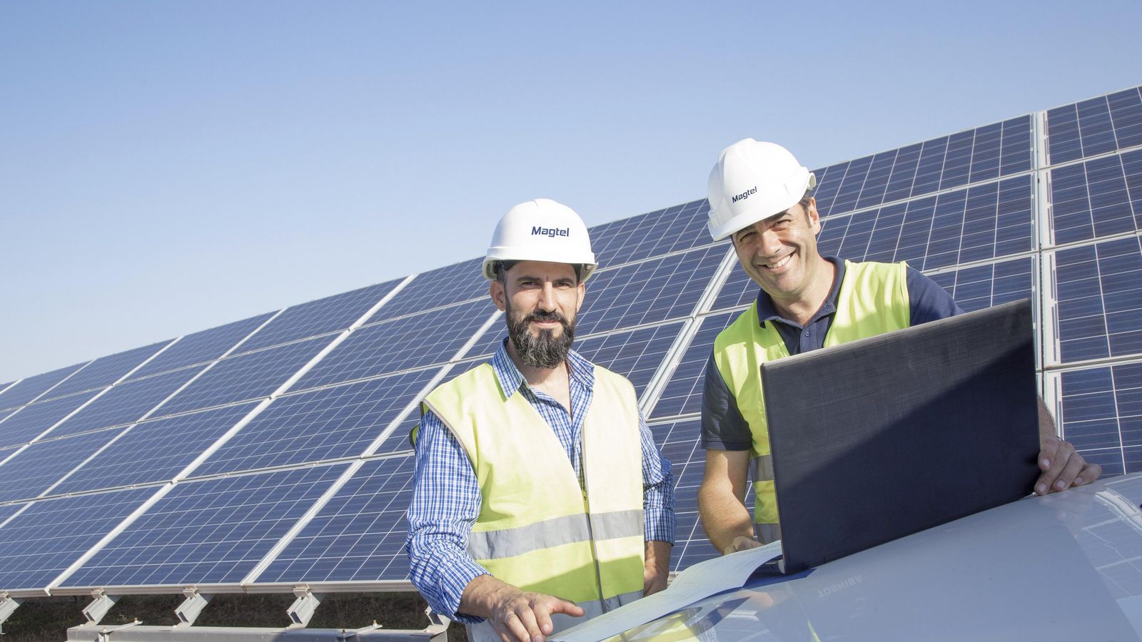 Dos empleados de Magtel en una instalación de energía renovable.