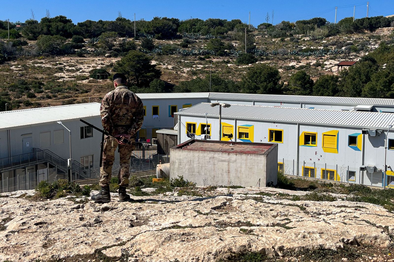 Un soldado del Ejército italiano vigila el único centro de acogida primaria de inmigrantes en la isla de Lampedusa.