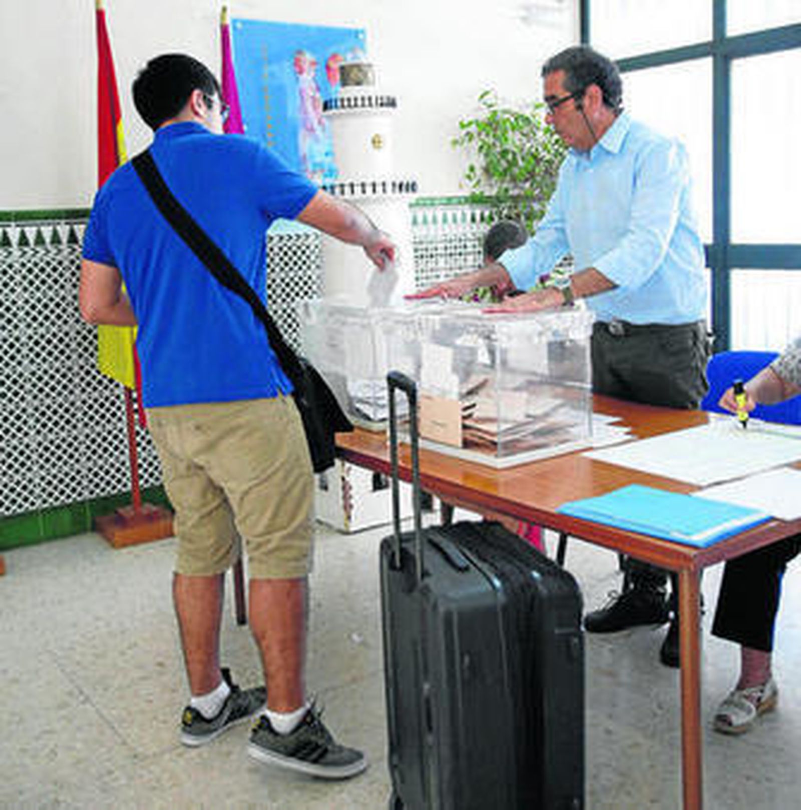 Un joven votando ayer con la maleta incorporada.