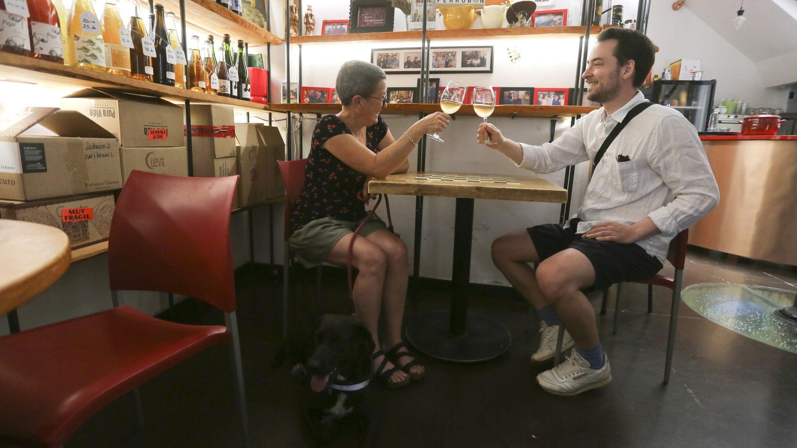 Dos personas toman vino en La Casa del Perro. Dos personas toman vino en La Casa del Perro.