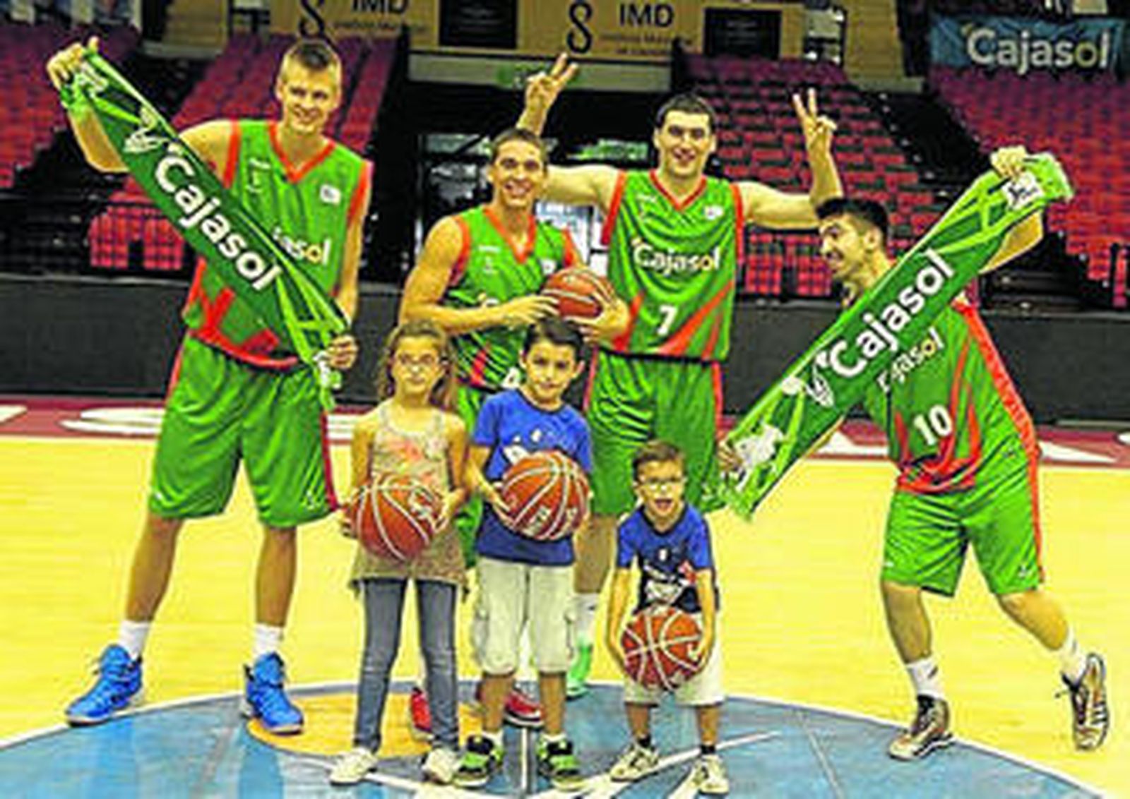 Algunos de los jugadores del Cajasol posan divertidos con los niños.