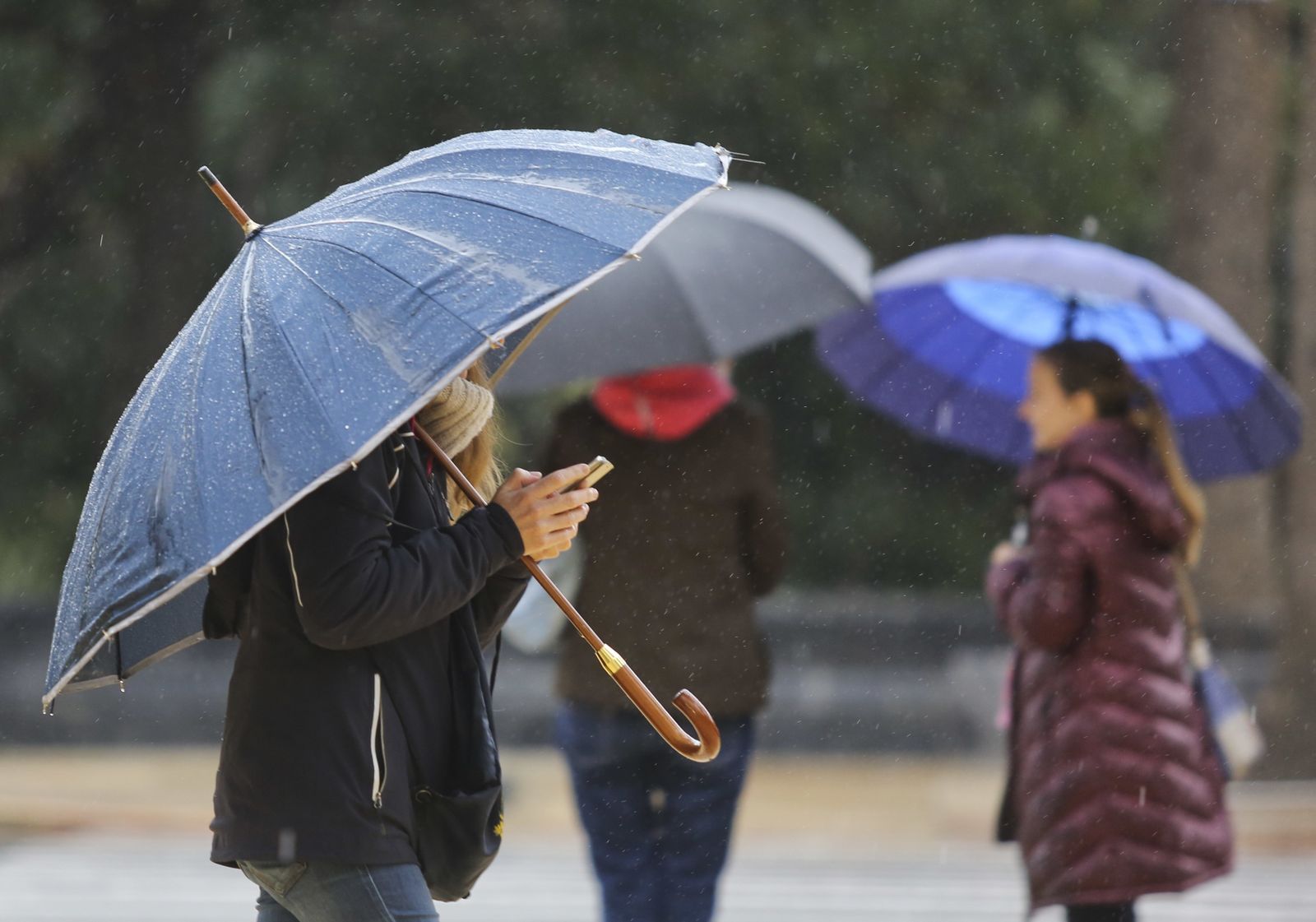 Varias personas se refugian de la lluvia este martes en la capital.