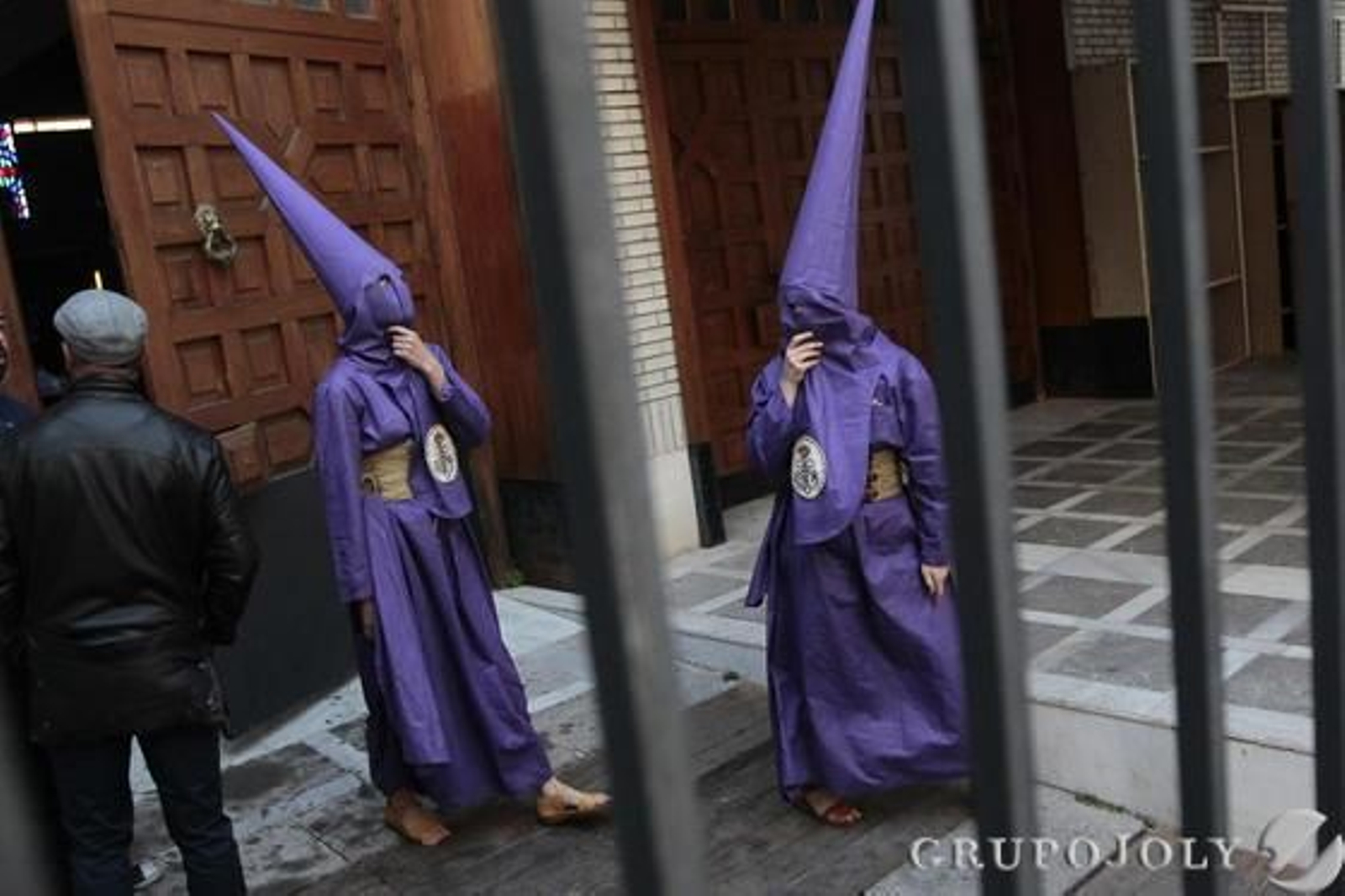 Dos hermanos de la Defensión esperan tras el enrejado de Capuchinos la comunicación de la junta de gobierno sobre si habría o no estación de penitenci

Foto: Jose Contreras