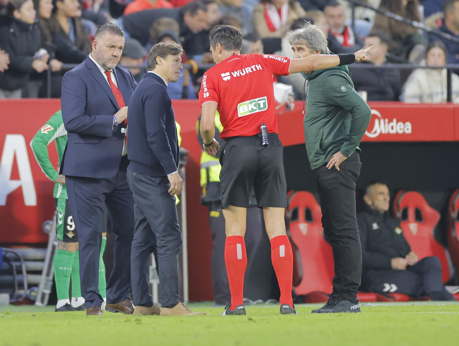El árbitro andaluz Munuera Montero advierte a Almeyda y Pellegrini del lanzamiento de objetos al campo.