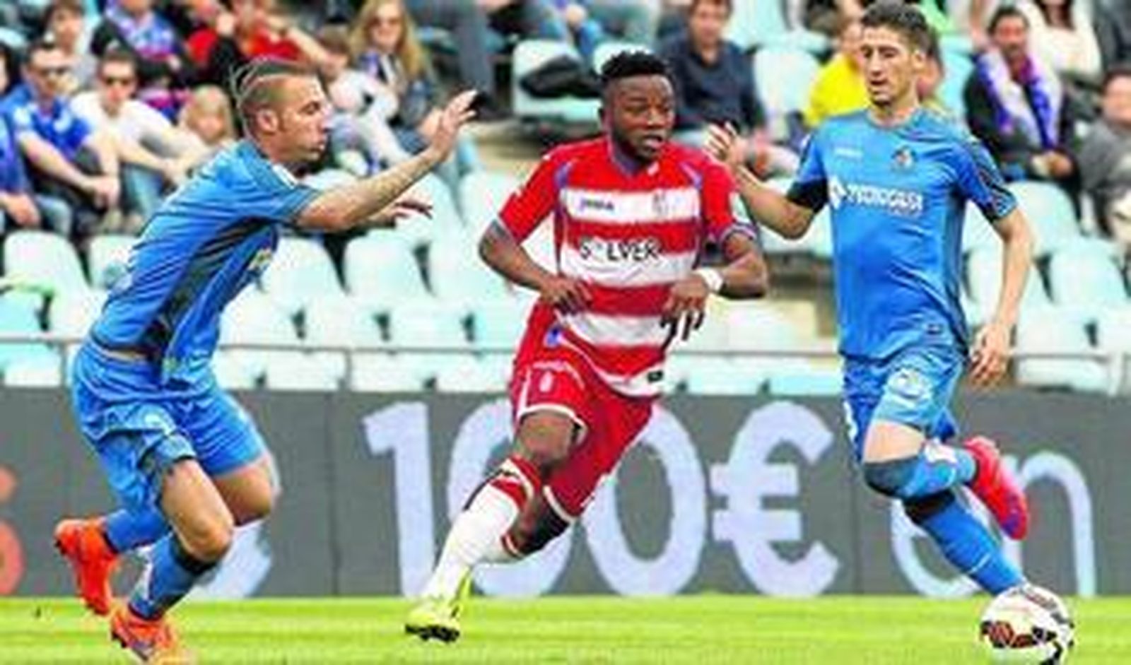 Lass Bangoura trata de zafarse de los zagueros del Getafe Alexis -a la izquierda- y Escudero -a la derecha-.