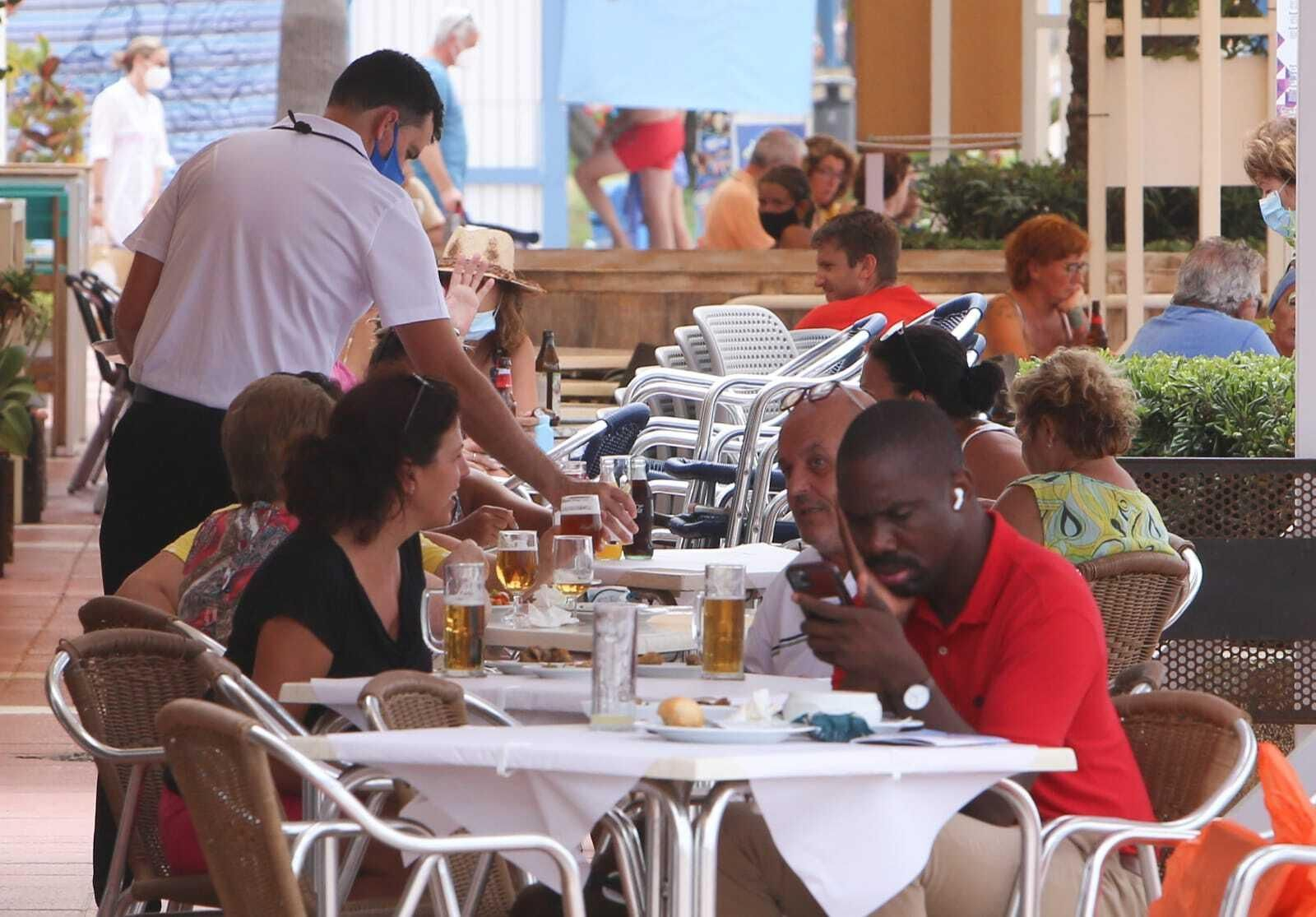Un camarero atiende una de las terrazas del paseo marítimo de La Barrosa.