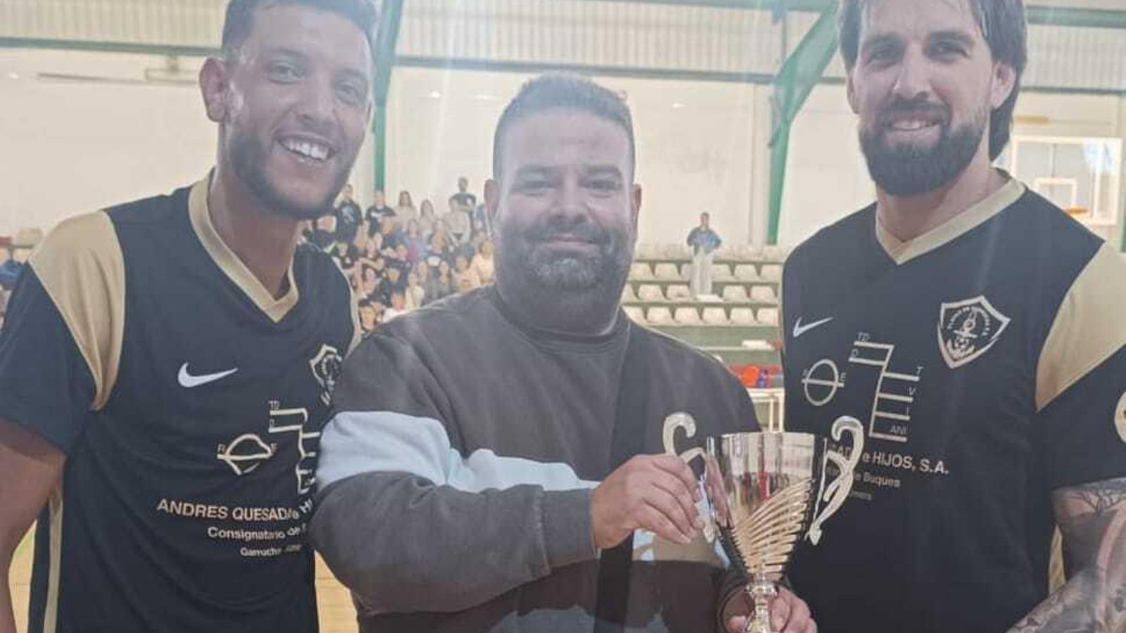 Los capitanes del equipo campeón recogen el trofeo.