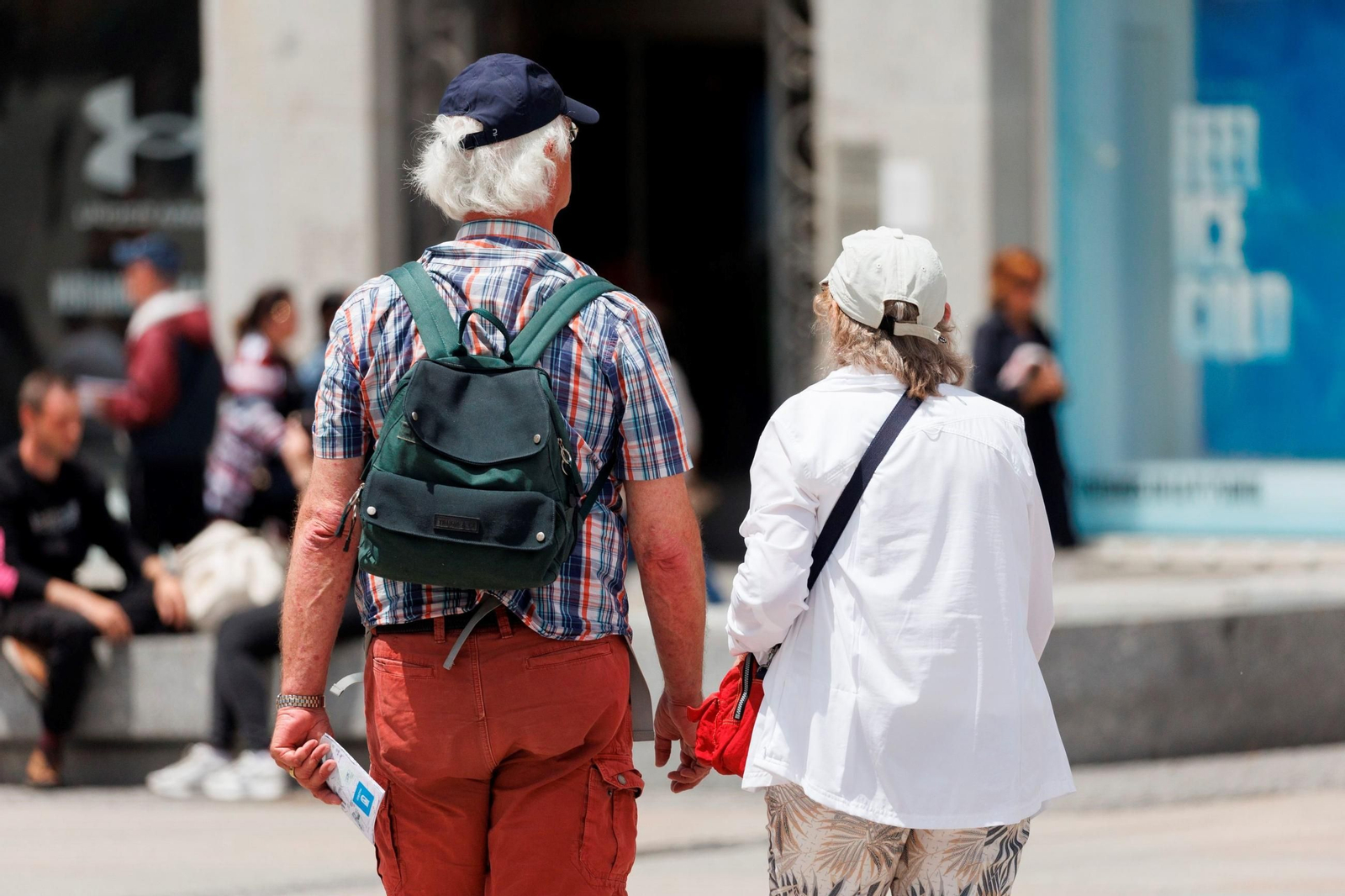 Dos extranjeros pasean de la mano.