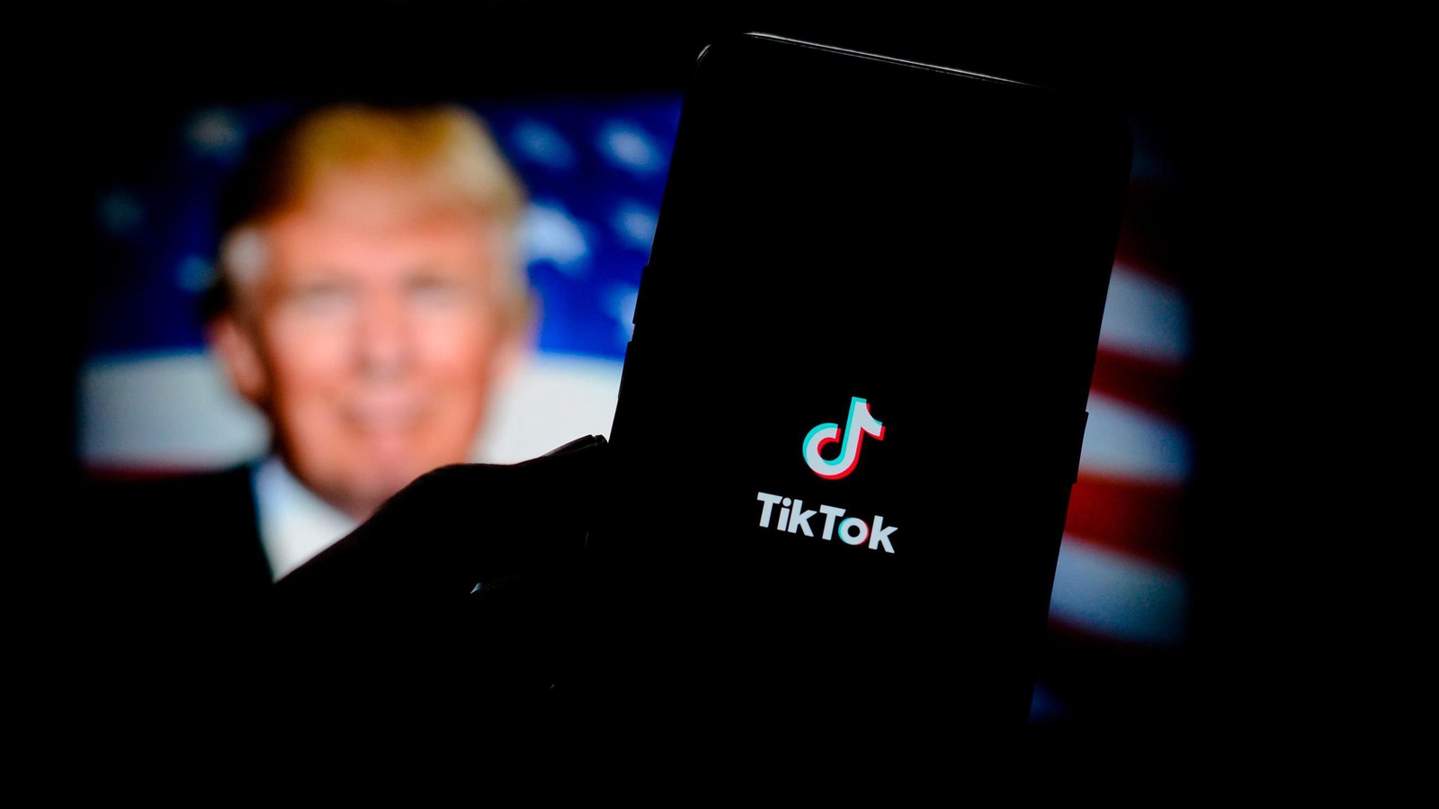 La aplicación de Tik Tok, con una imagen de Donald Trump al fondo.