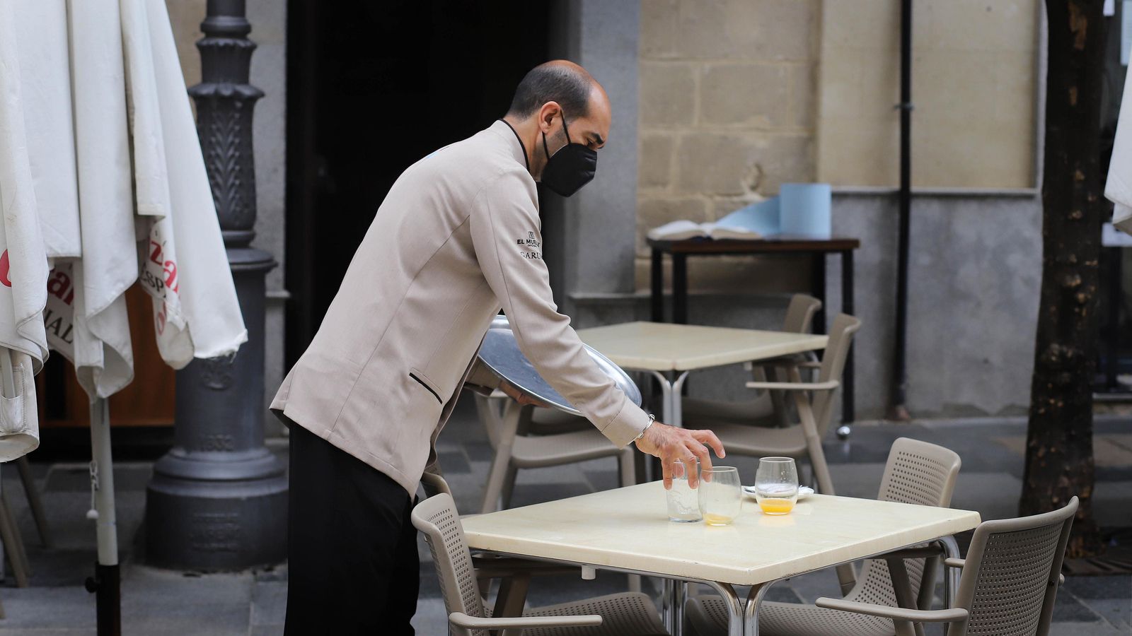 Un camarero recogiendo una mesa durante la pandemia, en una imagen de archivo. Un camarero recogiendo una mesa durante la pandemia, en una imagen de archivo.