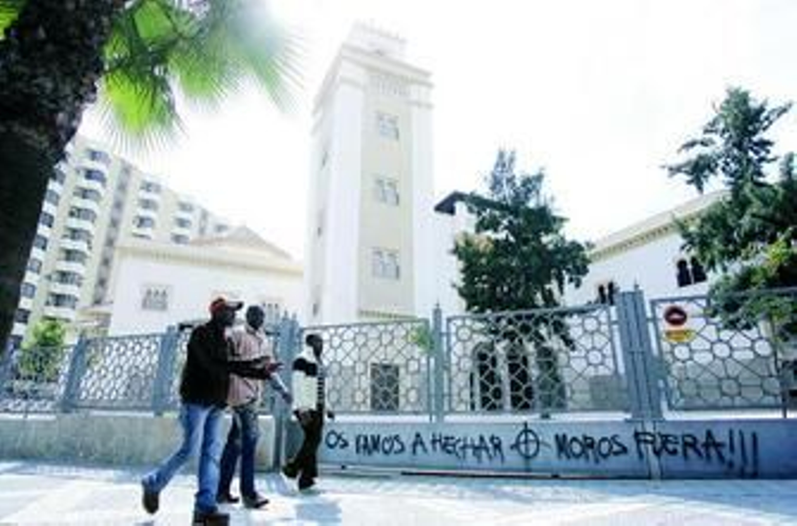 Tres inmigrantes pasan por delante de la mezquita de Ingeniero de la Torre Acosta.