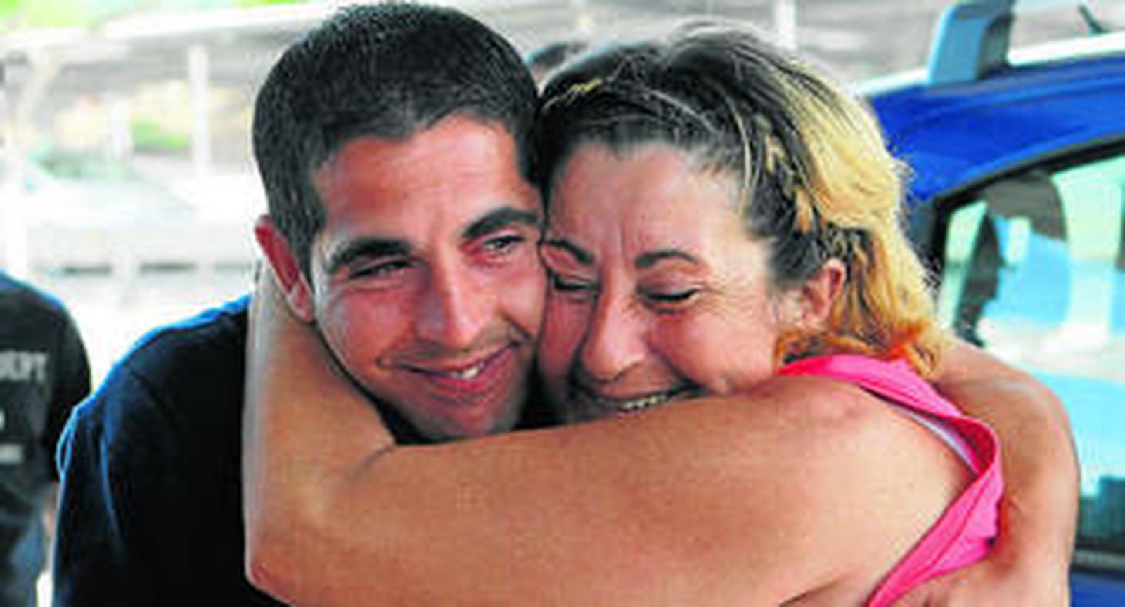 María Dolores Sánchez se abraza a uno de sus hijos a su llegada al aeropuerto de Barajas ayer.