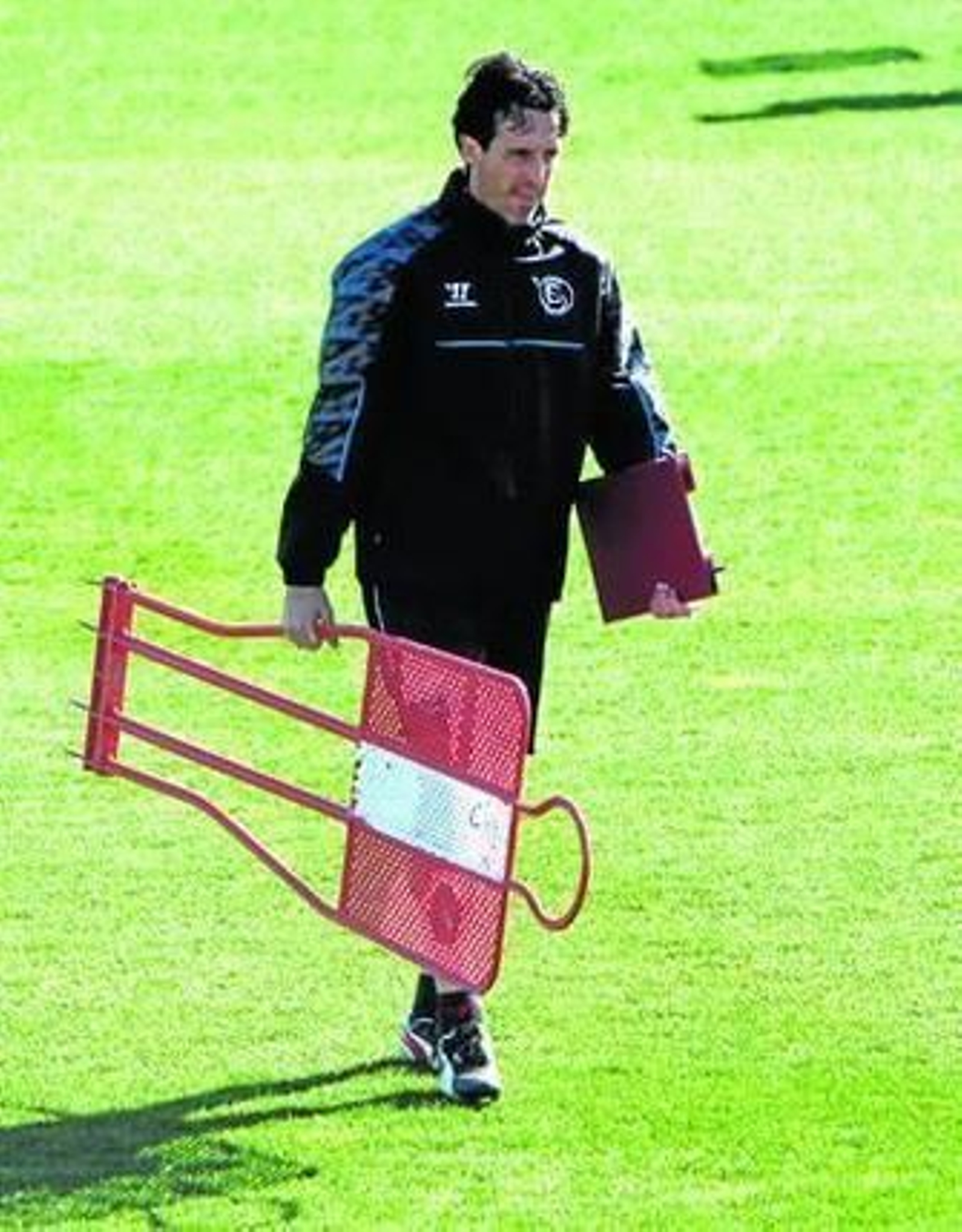 Unai Emery carga con un muñeco para la práctica a puerta cerrada.