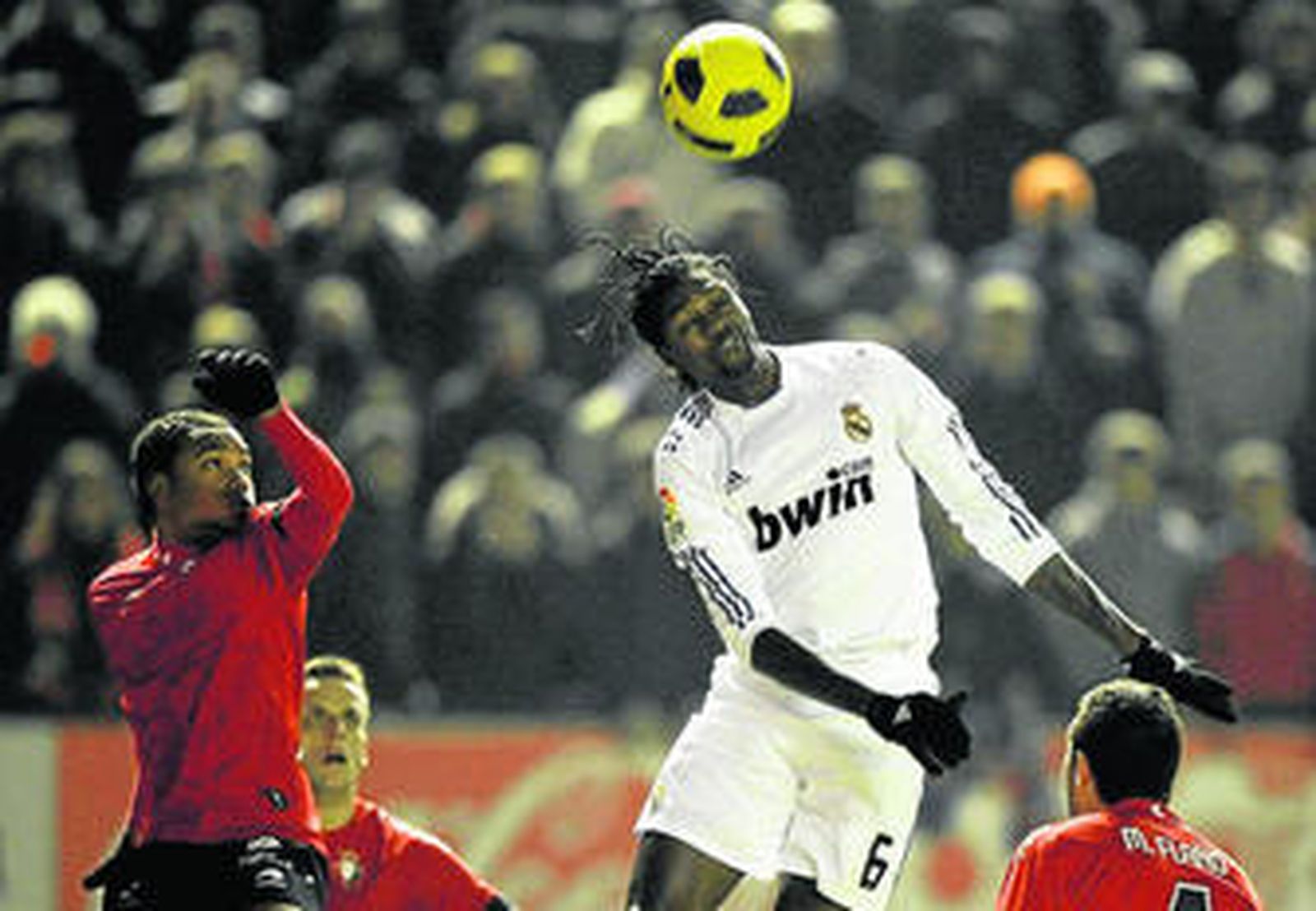 Adebayor se lleva un balón aéreo ante Nelson, Camuñas y Miguel Flaño en su debut con el Madrid.