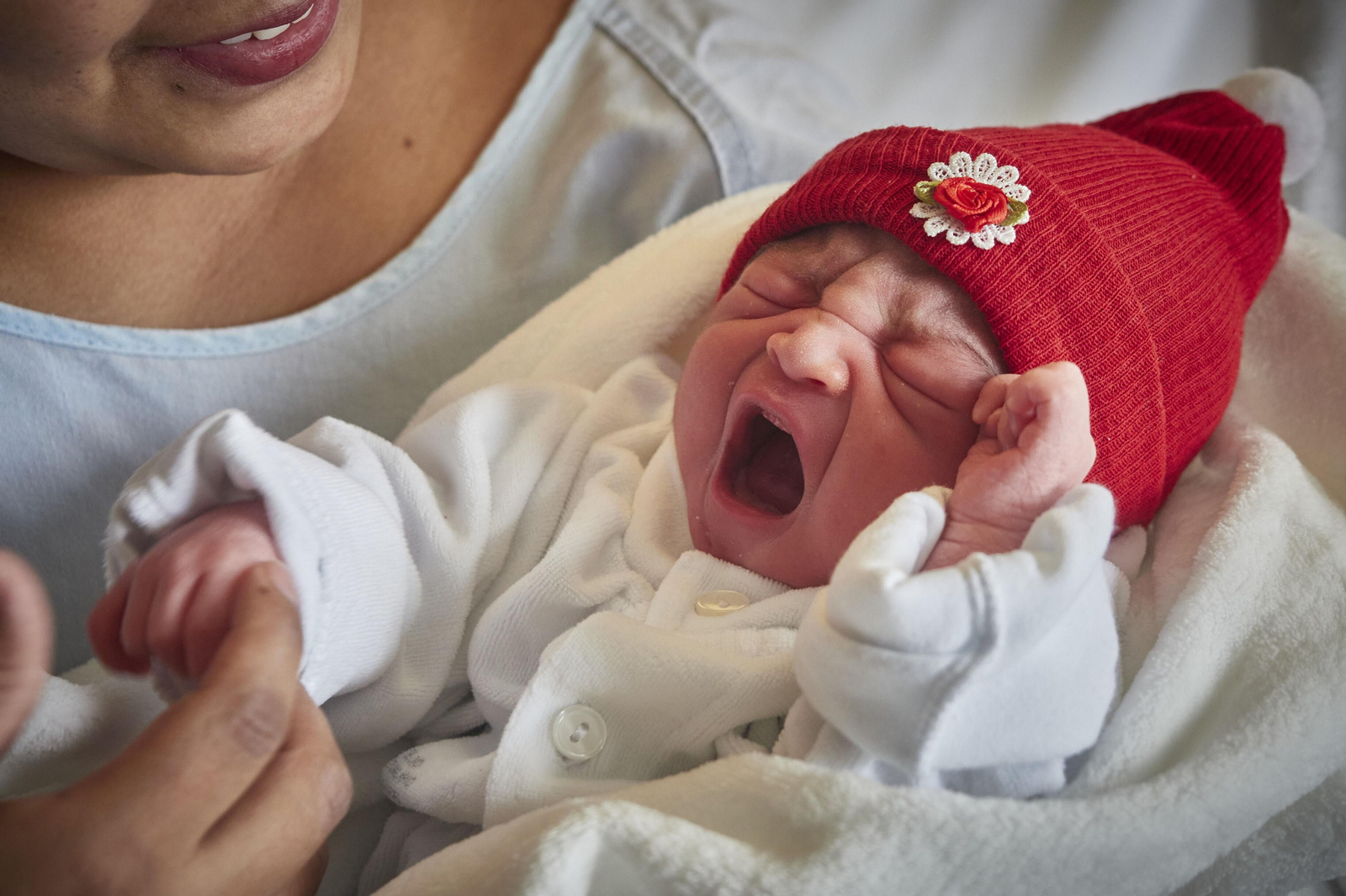 Un recién nacido, en manos de su madre en el hospital.