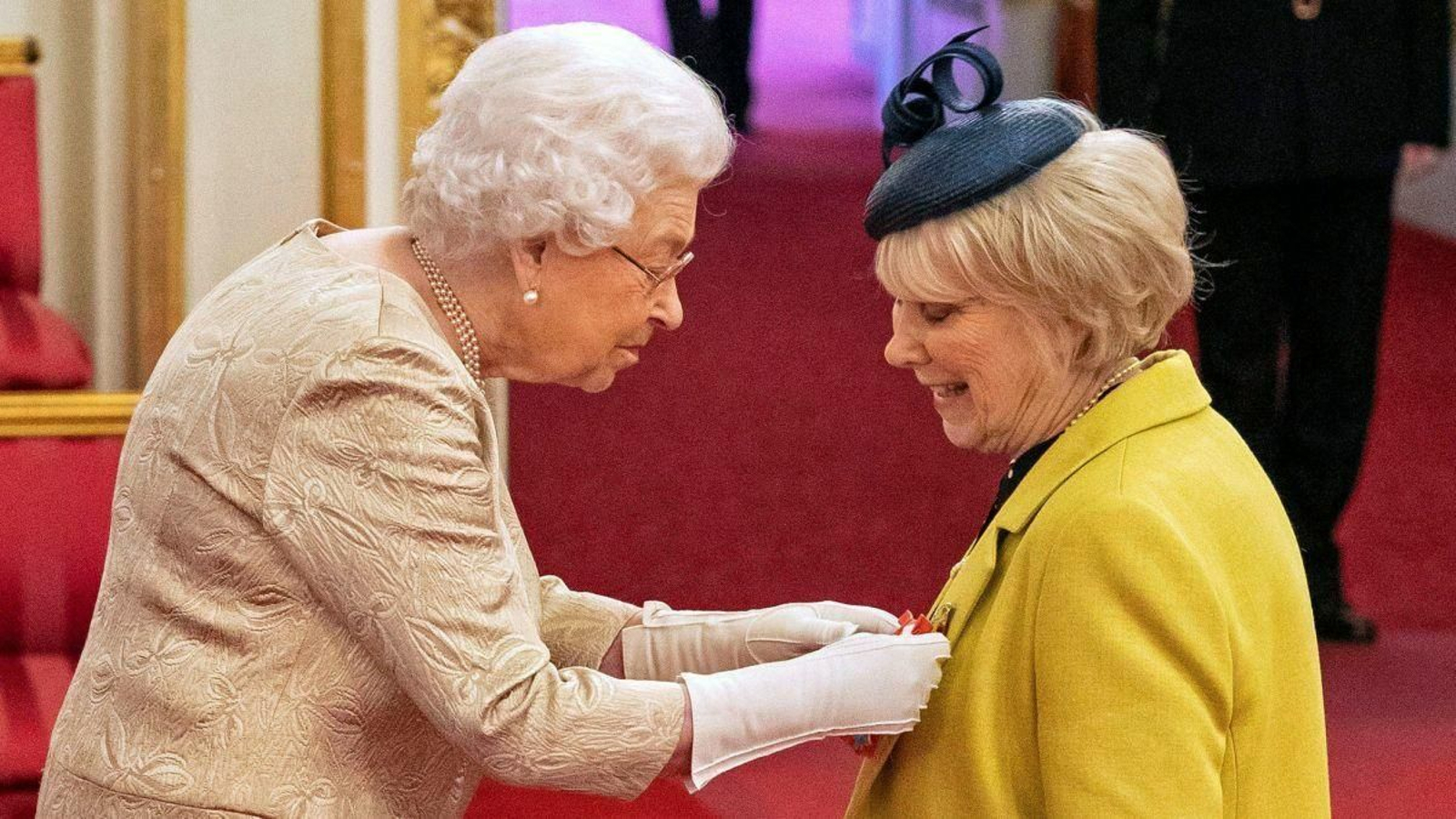 Isabel de Inglaterra, con guantes, en la ceremonia de condecoración de este miércoles en Buckingham.