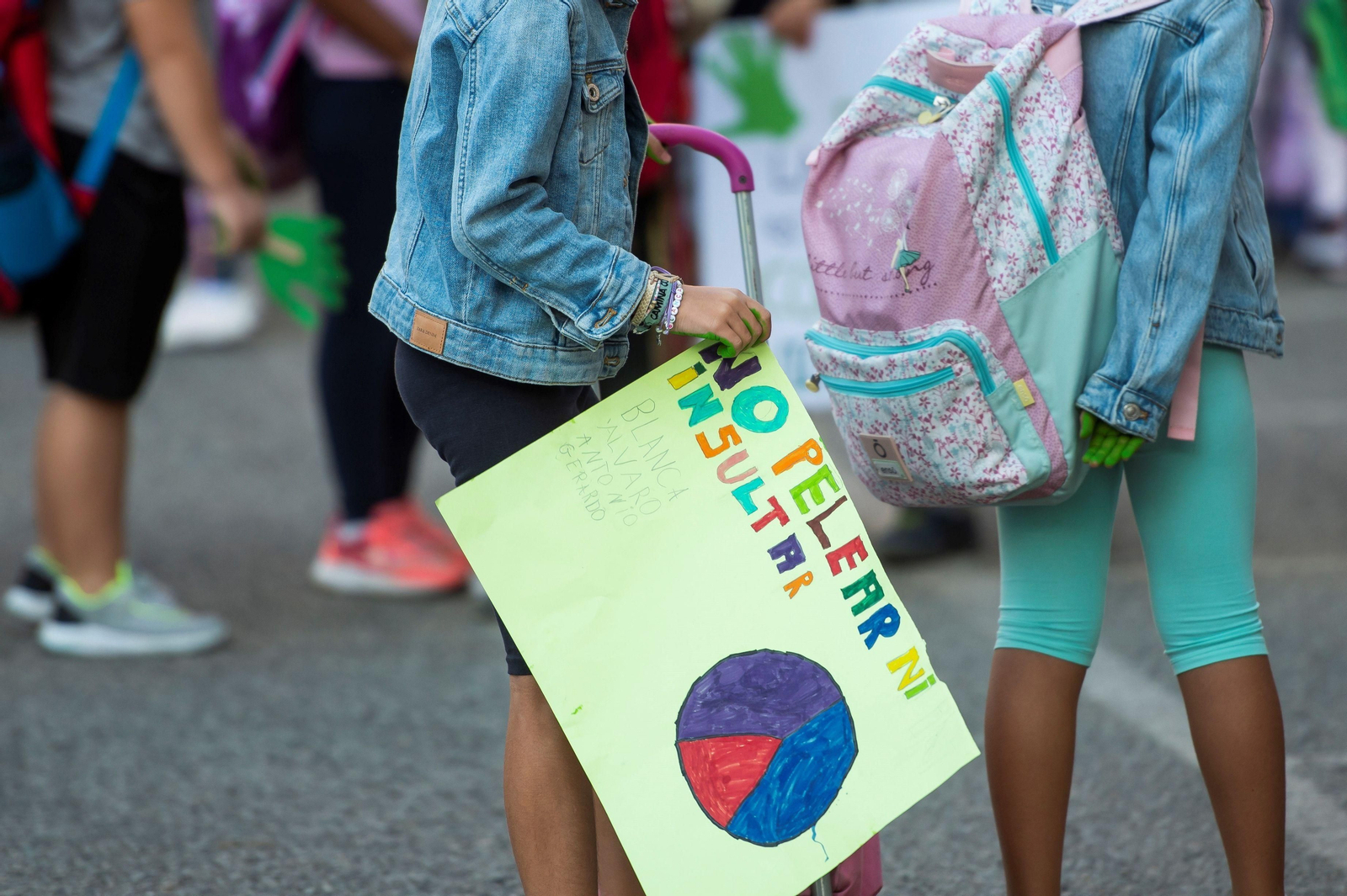 Una niña porta una pancarta contra la violencia en las aulas.
