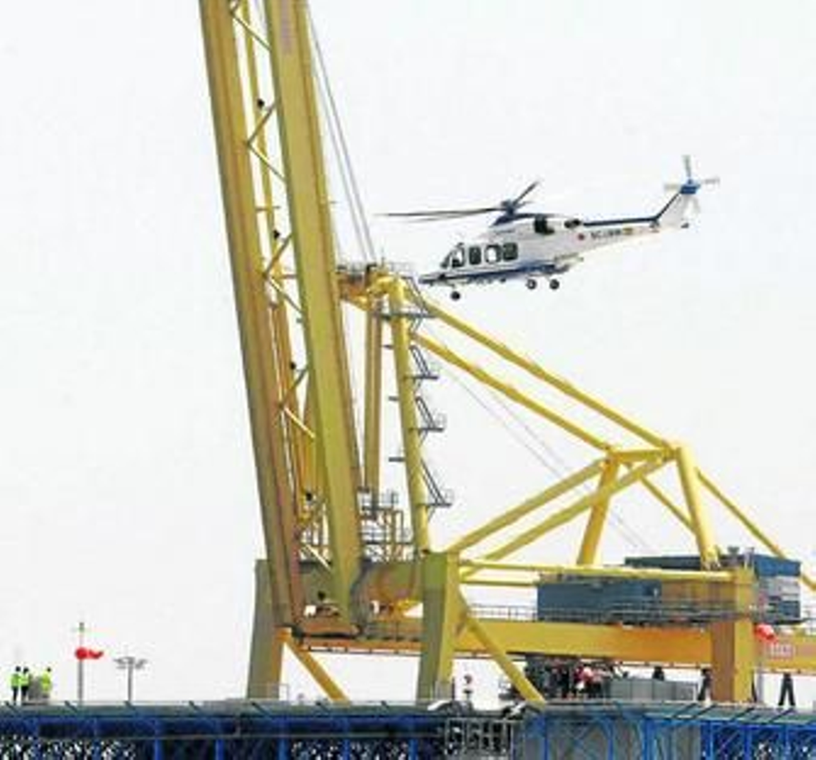 Un helicóptero aterriza en el puerto de Algeciras, ante una de las grúas de TCA.
