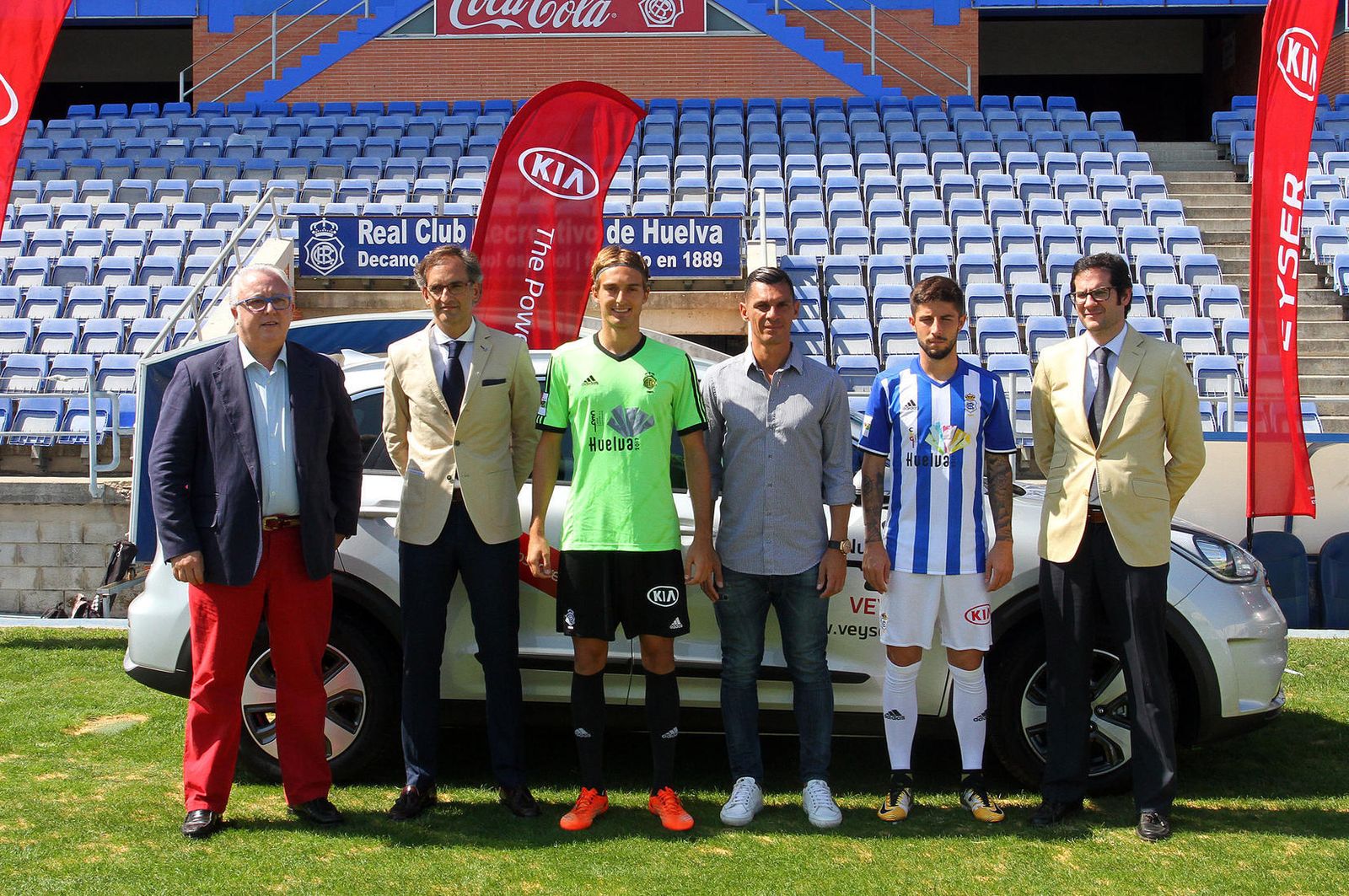 1. Responsables de KIA junto al técnico y los jugadores del Decano. 2. Antonio Domínguez y Sergio González lucen el logo de KIA en el pantalón. 3. Un Sportage a la salida del túnel de vestuarios. 4. Los tres vehículos que tendrá el Recreativo a su disposición esta temporada. 4. Operarios del Recre ultiman la esquina con la marca.