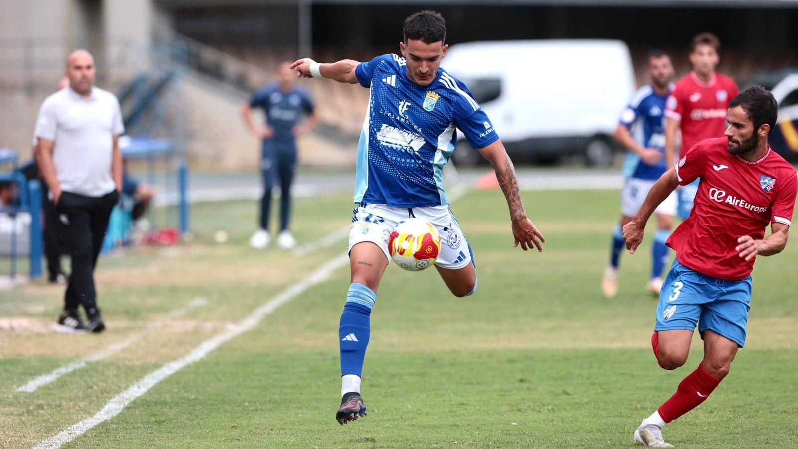 Chacartagui se lleva el balón pegado a la banda perseguido por Candelas.