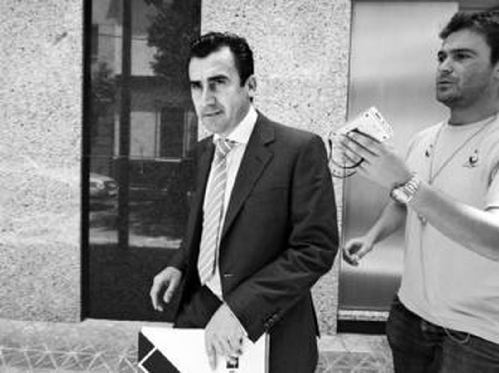 Luis Castel abandona las oficinas de Manuel Ruiz de Lopera en la calle Jabugo seguido por un periodista.