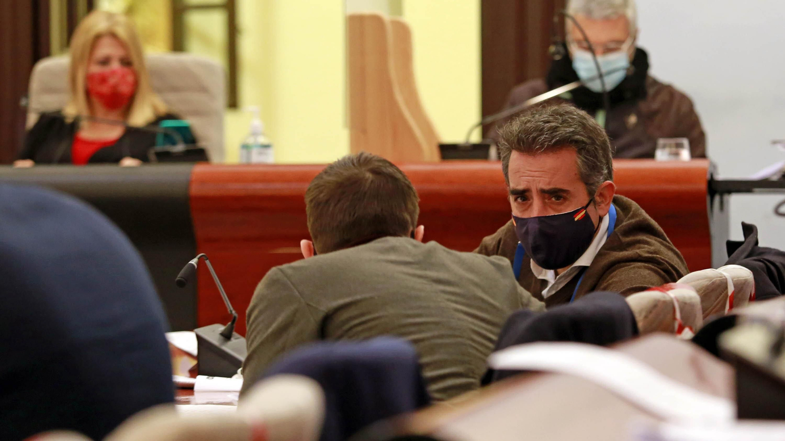 El concejal Jaime Espinar, de espaldas, conversando con Antonio Saldaña durante un pleno.